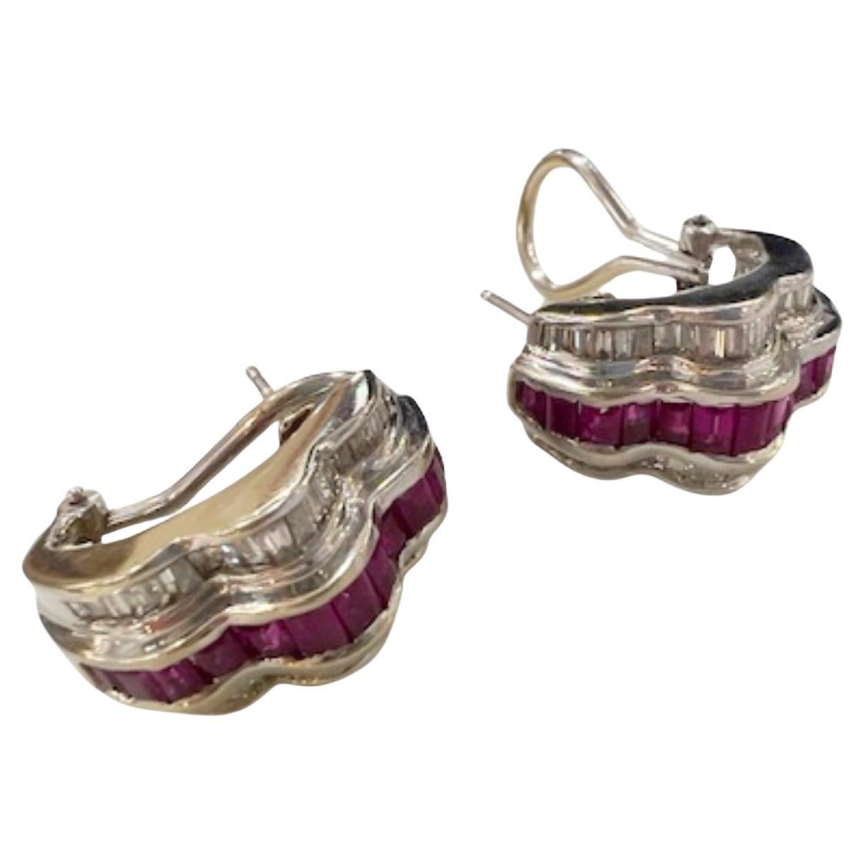 These contemporary earrings are crafted in 18K gold and feature diamonds and rubies. They weigh 10.38 grams. 
The earrings include 72 trapezoid-cut diamonds, totaling 1.44 carats, with SI-VS clarity and G-H color. They also feature 26 baguette-cut