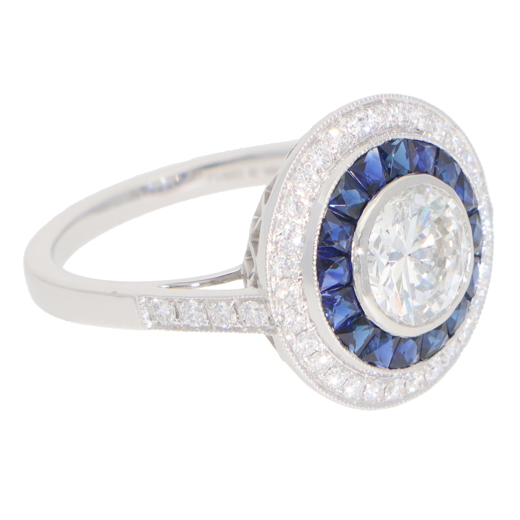 A beautiful Art Deco style diamond and sapphire double target ring set in platinum.

The ring is predominantly set with a sparkly round brilliant-cut diamond in a bezel setting. Surrounding this beautiful diamond are two targets - one comprised of