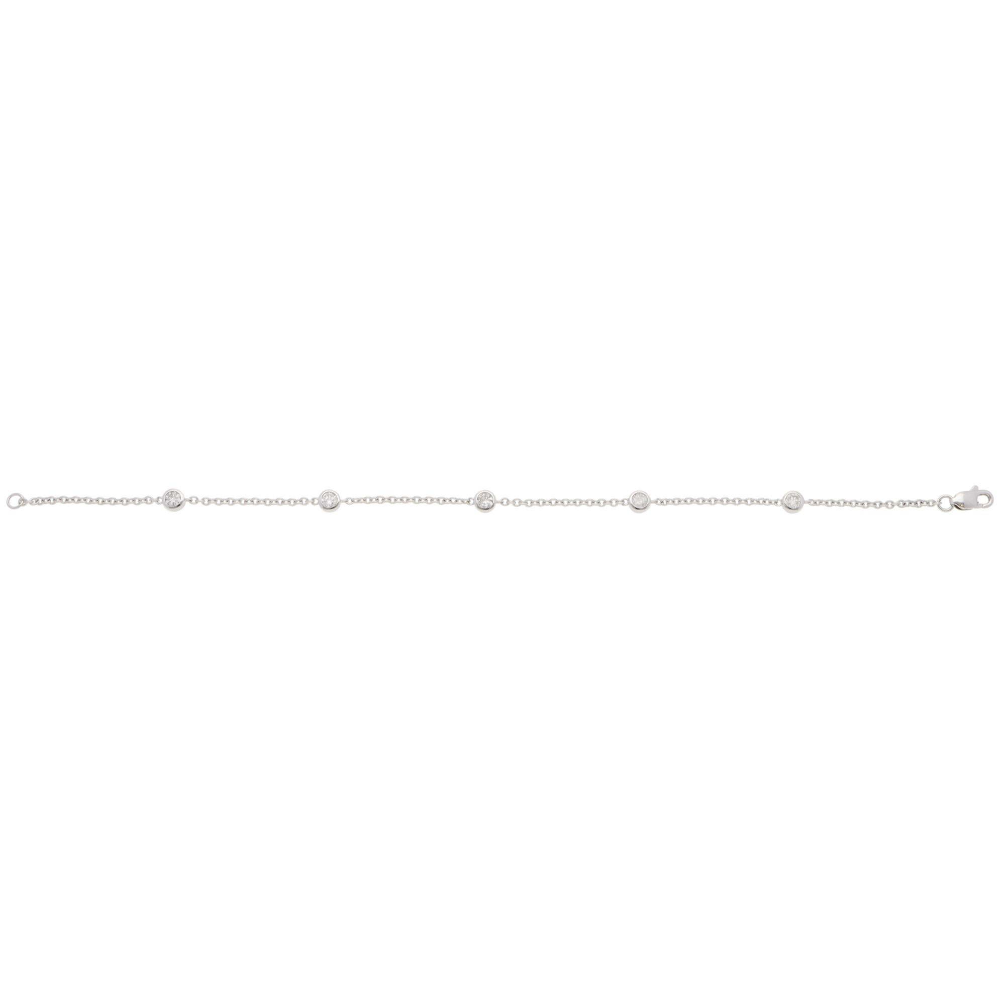 Un bellissimo bracciale contemporaneo con catena di diamanti in oro bianco 14 carati.

Il bracciale è composto da 5 diamanti rotondi con taglio a brillante collegati da catene in oro bianco, fissate con una chiusura a moschettone. Ogni diamante è