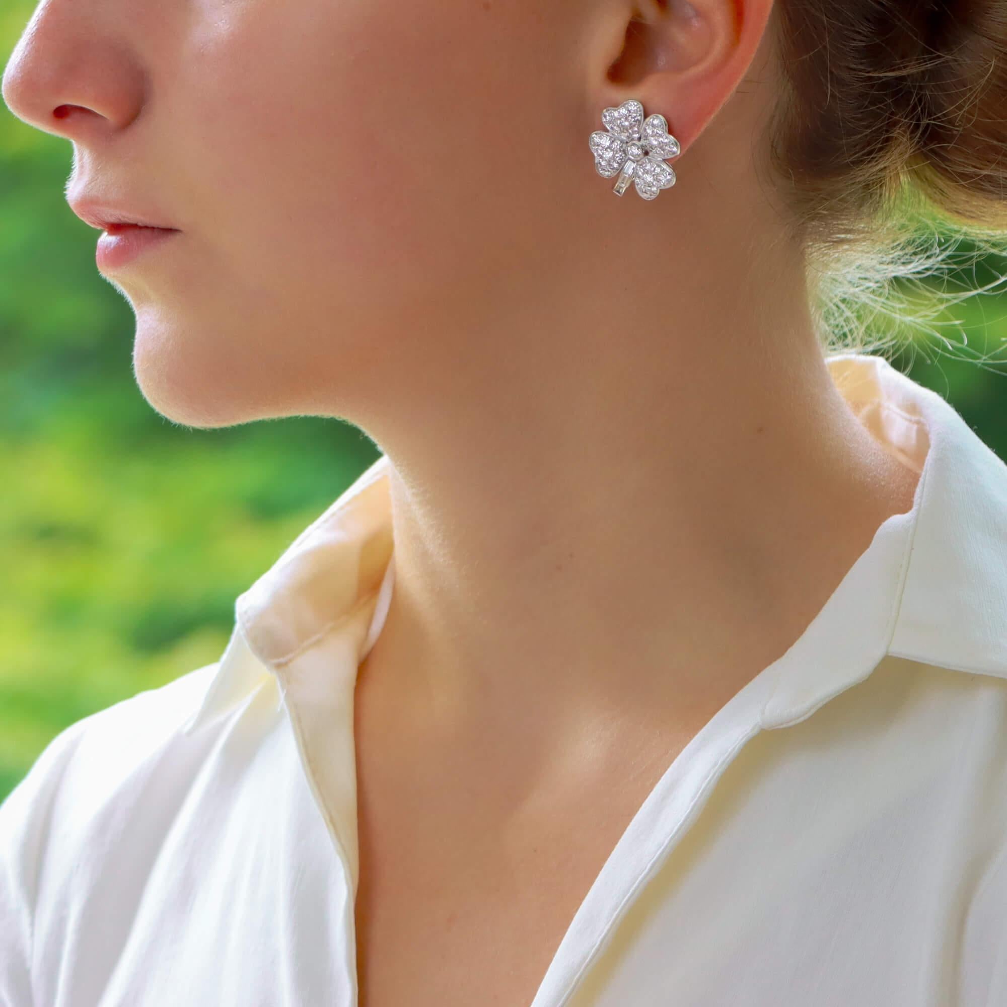 A sparkly pair of clover diamond earrings/pendants in platinum. Each earring/pendant is designed as a quatrefoil clover millegrain-set to the centre with a round brilliant-cut diamond, each leaf pave-set with similarly-cut diamonds and decorated
