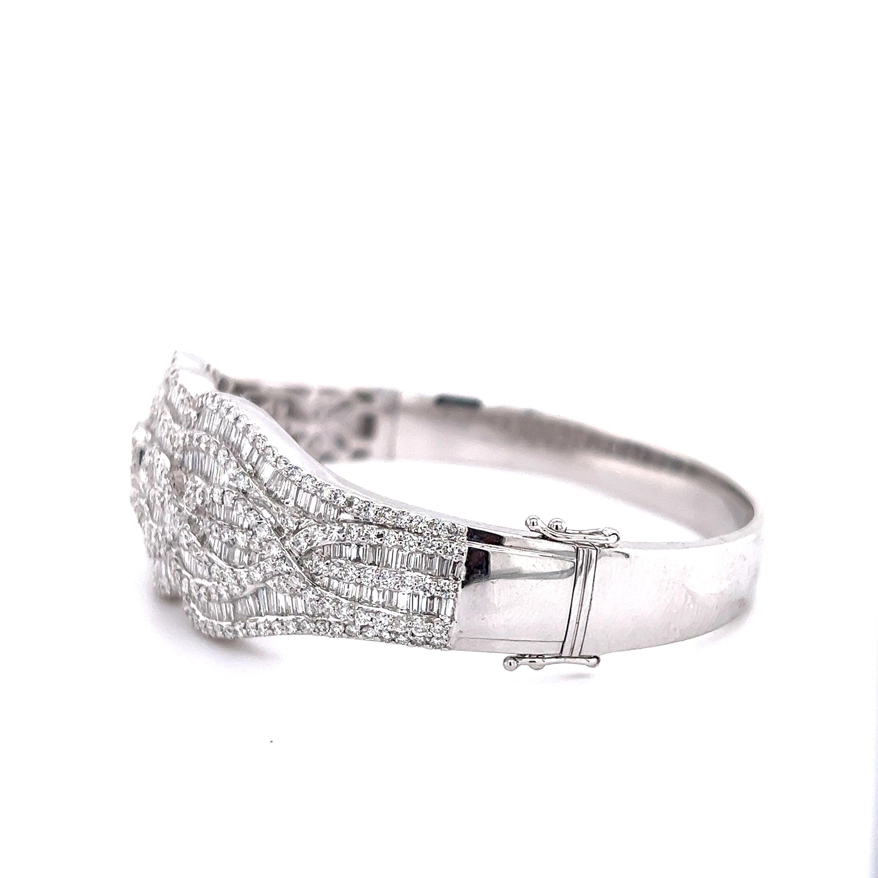 Gorgeous diamond cuff bracelet crafted in 18k white gold. The design is set with over 15.01 ct. of round brilliant cut & baguette cut earth mined natural diamonds. The cuff shows a whimsical pattern as the diamonds seem to flow endlessly across the