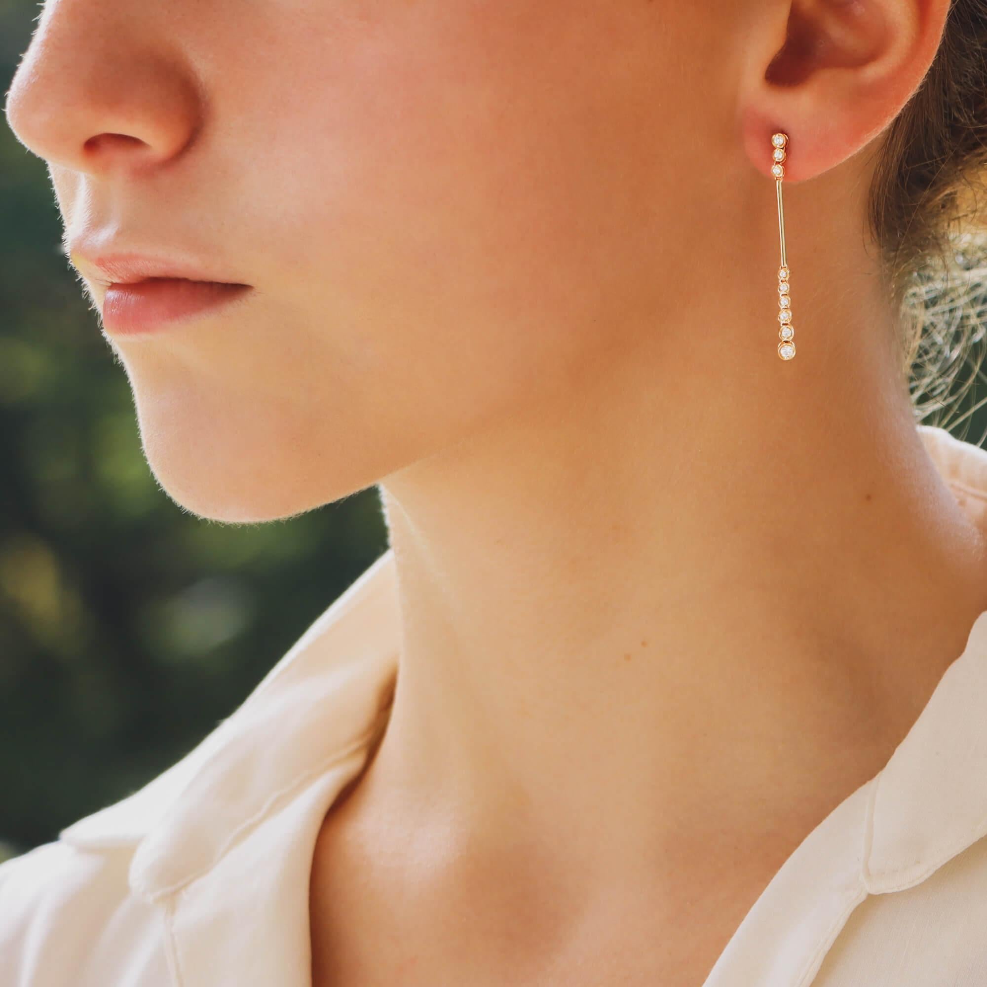 Ein schönes Paar Diamant-Ohrringe in 18 Karat Gelbgold.

Jeder Ohrring besteht aus einem einfachen, schlanken Tropfen. Oben sind drei runde Diamanten im Brillantschliff eingearbeitet, die an einem massiven Barren aus 18 Karat Gelbgold hängen. Von