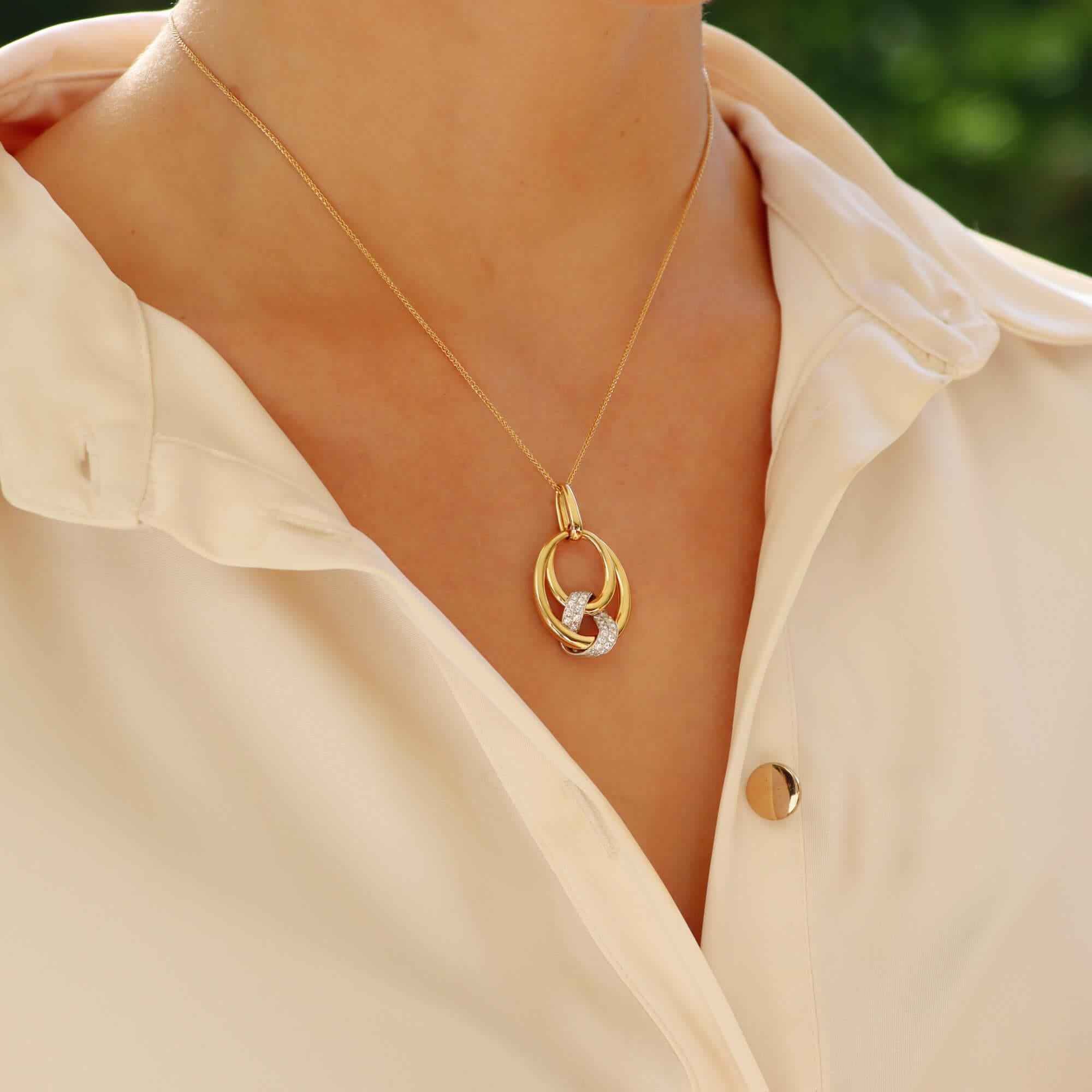 Un elegante collar colgante de diamantes inspirado en los años 80, engastado en oro amarillo y blanco de 18 quilates.

El colgante se compone en primer lugar de un aro de oro amarillo, que cuelga de una abrazadera de oro en una cadena Spiga de oro