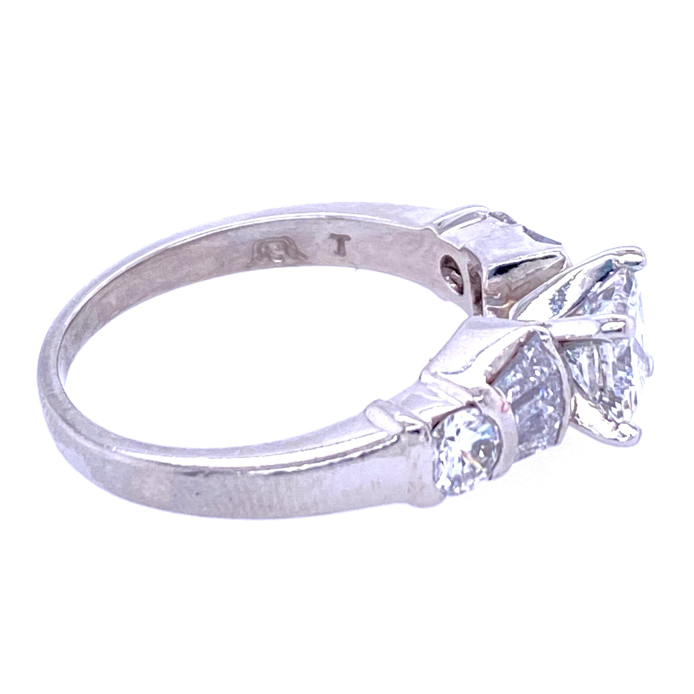 Platinum (stamped PLAT) set with 5x4.75mm princess cut diamond, 0.75 carat with H color and SI2 clarity flanked by three tapered baguettes on either side, approximately 0.30 carat total weight and one 3.5mm round brilliant diamond, approximately