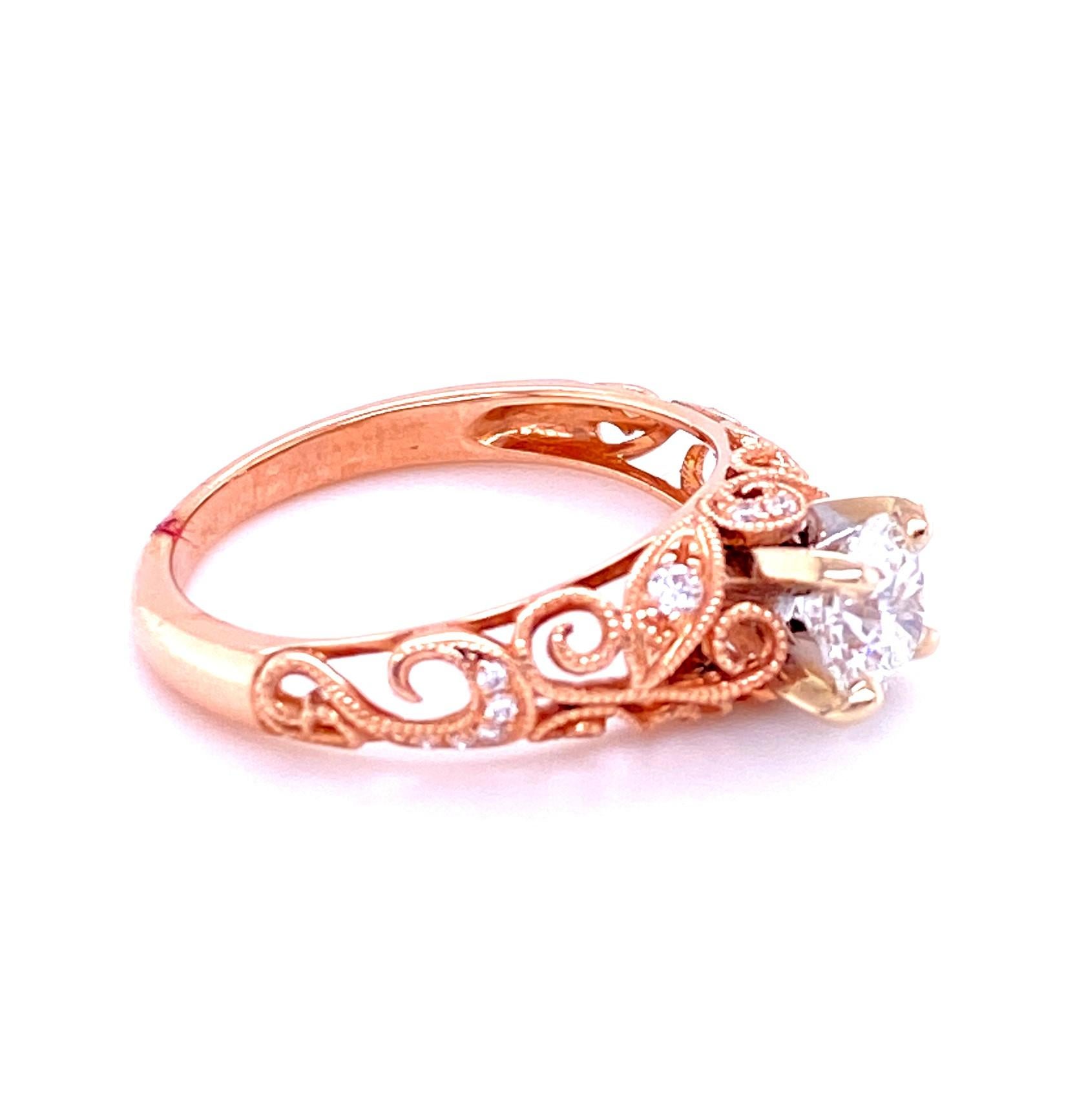 14 karat rose and white gold Art Nouveua inspired contemporary diamond engagement ring set with one 0.72 carat round brilliant diamond with G color and SI1 clarity set in a four prong white gold head on an open work rose gold mounting with a leaf