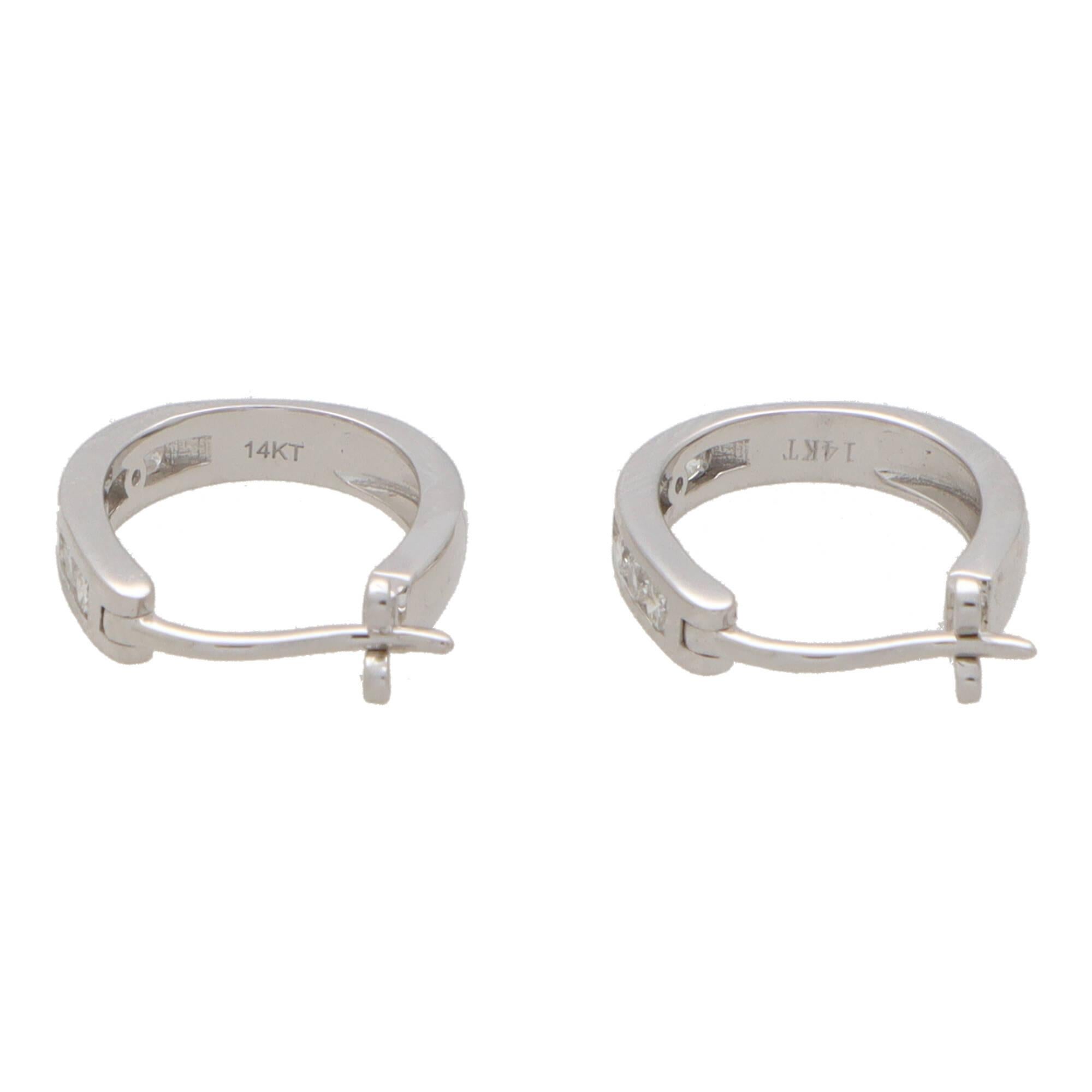 A perfect everyday pair of diamond hoop earrings set in 14k white gold.

The earrings are channel set to the front with seven round brilliant cut diamonds and secured with a post and click shut fitting.

Due to the design and size these earrings