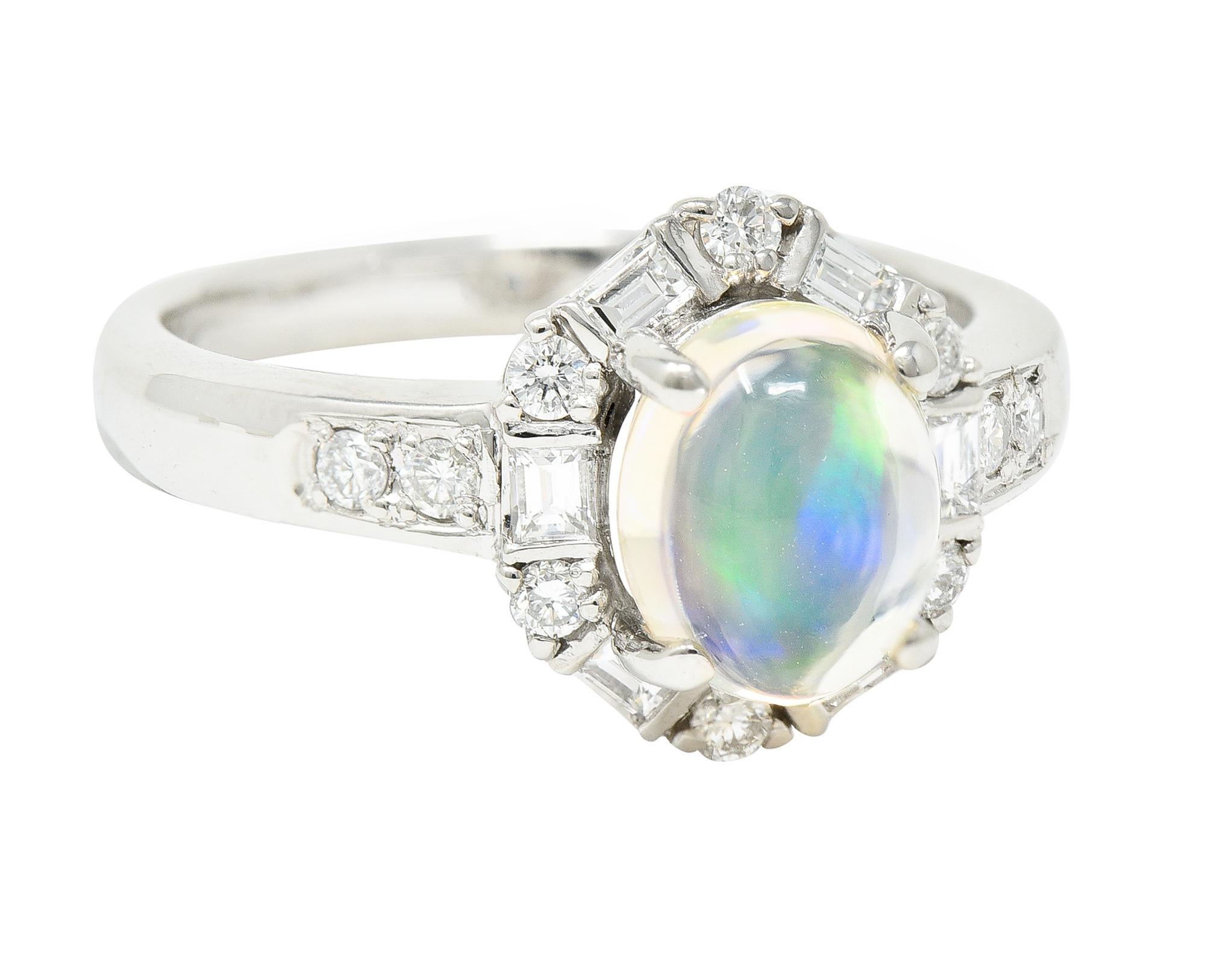 Centering an oval jelly opal cabochon measuring 6.6 x 8.0 mm. Colorless body with spectral play-of-color; prong set. Featuring a halo surround of baguette and round brilliant cut diamonds. Prong set and weighing approximately 0.49 carat total. G/H