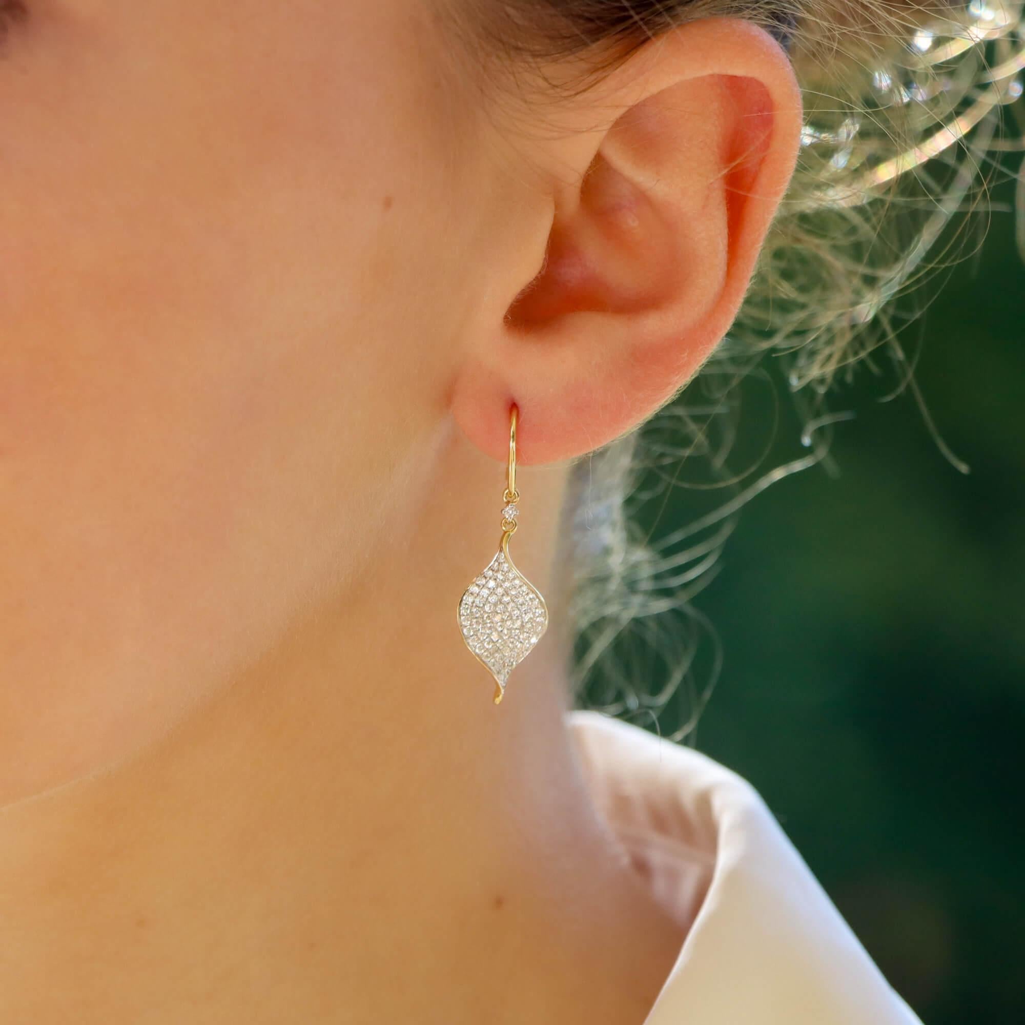 A gorgeous pair of contemporary diamond leaf drop earrings set in 18k yellow gold.

Each earring is firstly composed of a diamond set leaf, designed with a slight twist so that the diamonds catch the light from all angles once on the ear. The leaf