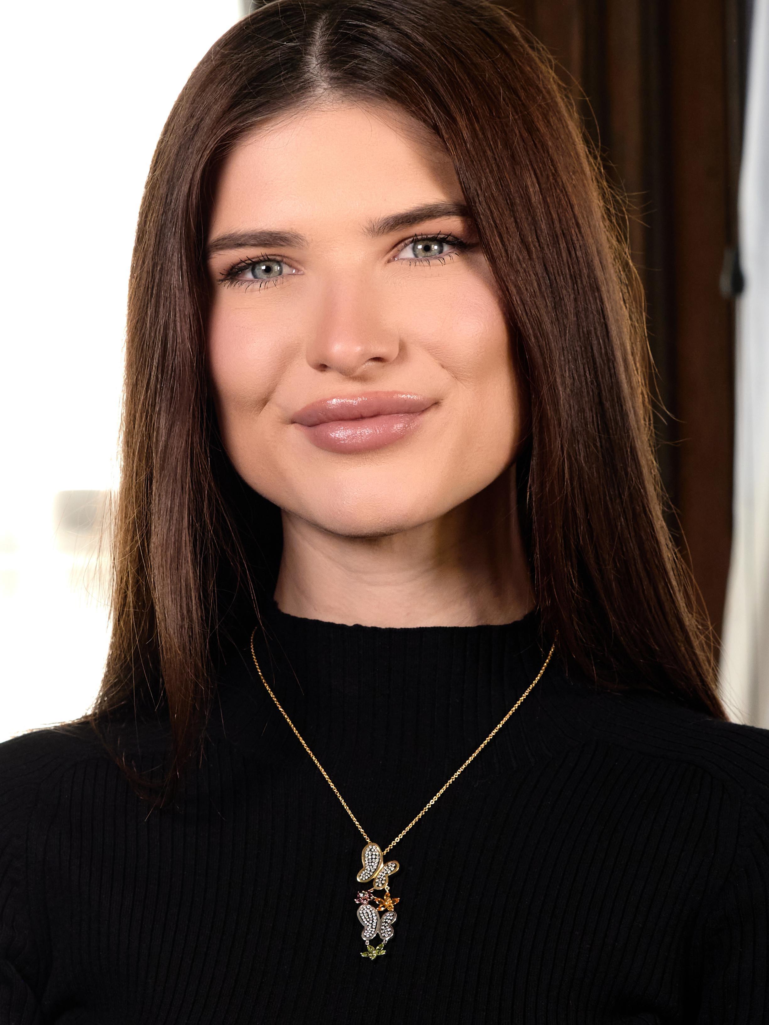 Designed as a yellow gold cable link chain suspending a butterfly and flower pendant
Tiered with one white gold and one yellow gold butterfly - with clear acrylic wings
Bezel set by gold surrounds and flush set with round brilliant cut
