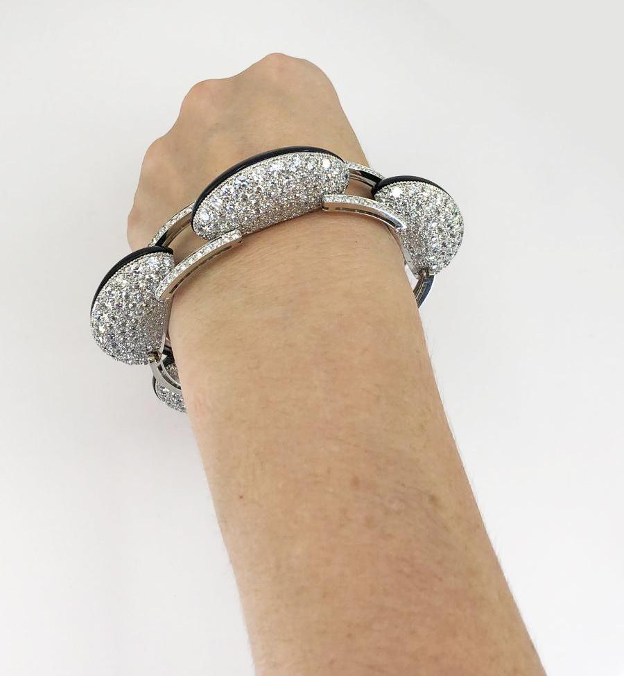 Contemporary Diamond Onyx Bombe Link Bracelet in Platinum.

A contemporary bracelet with hints of Art Deco with geometric Modernism. Each crescent-shaped bombé link features diamond pavé on one side, with custom-carved onyx panels mirrored on the