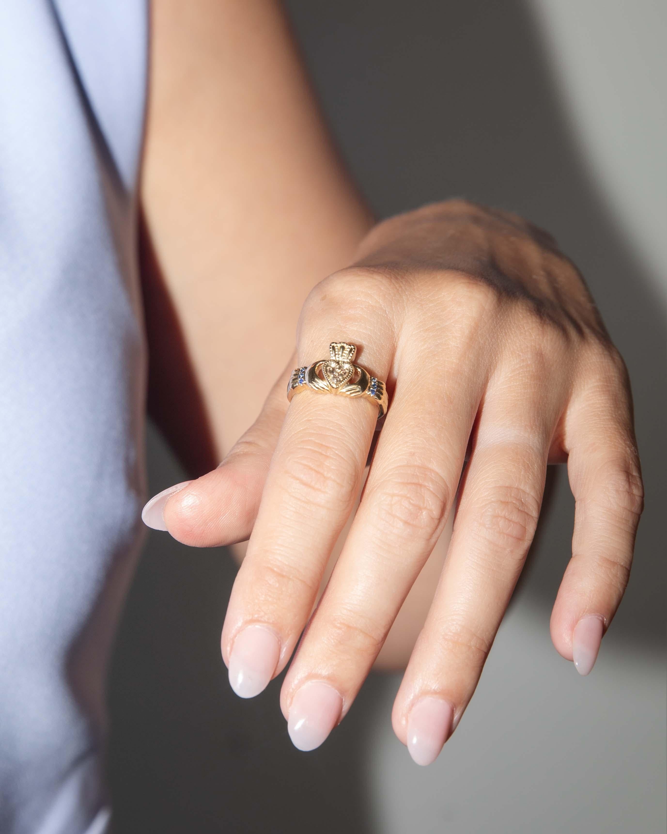 Der Claddagh-Ring von Selah ist ein dauerhaftes Symbol für Liebe, Treue und Freundschaft. Er ist meisterhaft aus reichem 10-karätigem Gelbgold gefertigt. In seinem Herzen schmiegen sich drei Diamanten im Rosenschliff in ein gekröntes Herz, das von