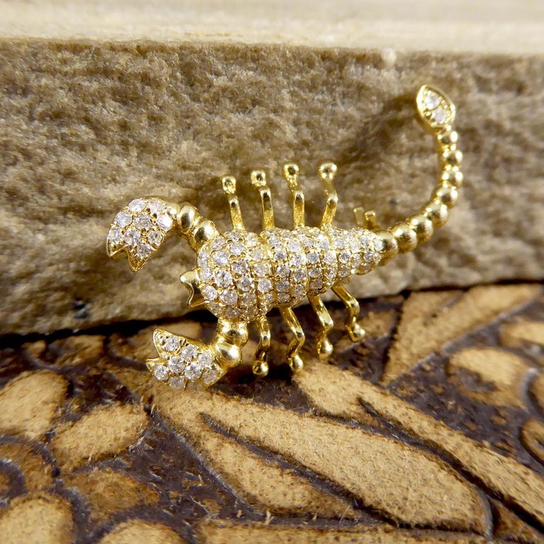This lovely little Scorpion piece can either be worn as a pendant or a brooch depending on the occasion. It has been fully crafted from 18ct Yellow Gold and is adorned with white Diamonds throughout the body and pincers. If you are looking to add a