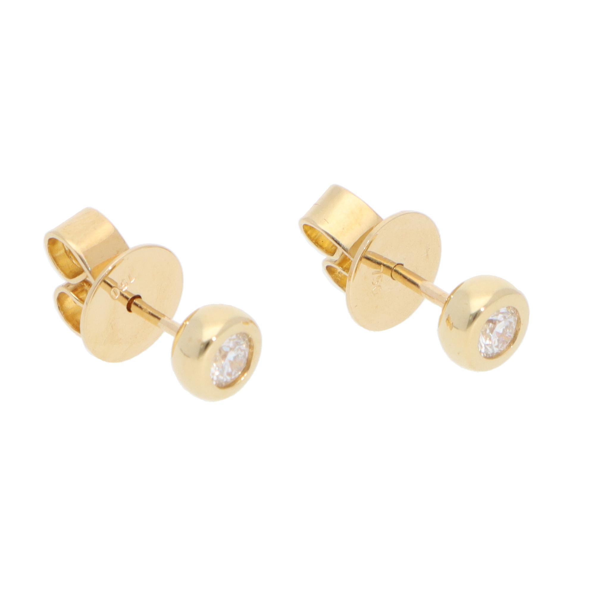 Un bellissimo paio di orecchini contemporanei con diamanti incastonati in oro giallo 18 carati.

Ogni orecchino presenta esclusivamente uno scintillante diamante rotondo con taglio a brillante, incastonato al centro. Ciascuna borchia è incastonata