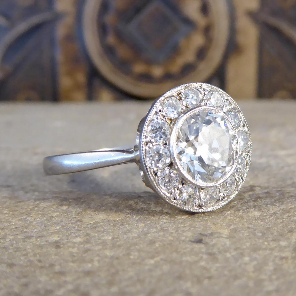 Such an exquisite Contemporary target ring featuring a 1.15ct European Cut Diamond in the centre in a millegrain rub over collar setting with a circular surround of 12 Diamonds weighing 0.40ct together setting. Target rings were first seen in the