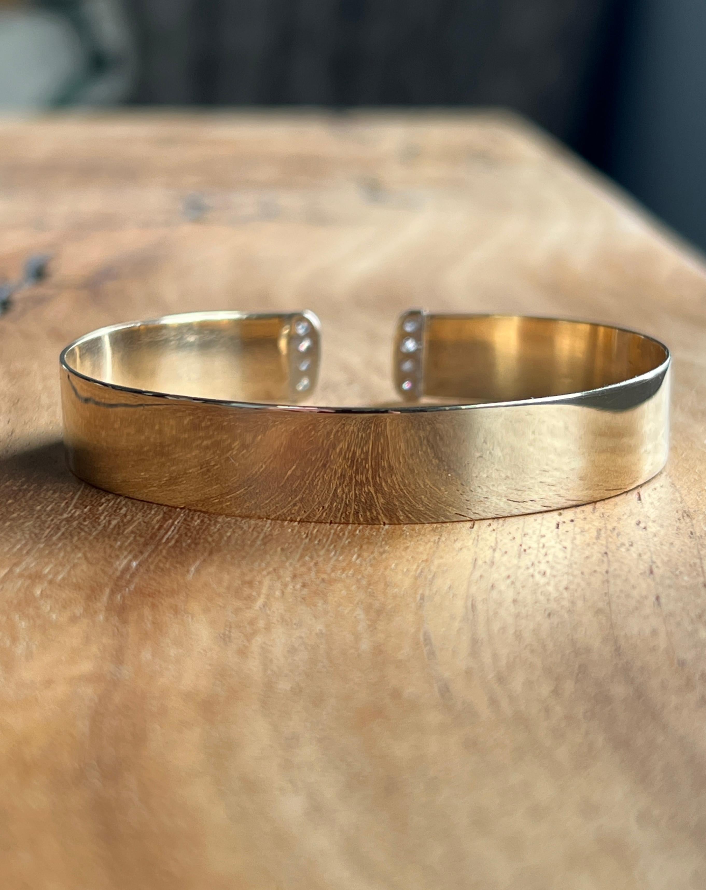 Bold yet refined, this contemporary cuff bracelet is crafted in 14 karat yellow and white gold and features eight round brilliant cut diamonds with an approximate total carat weight of 0.24. The diamonds, graded G–H in color and SI2 in clarity, are