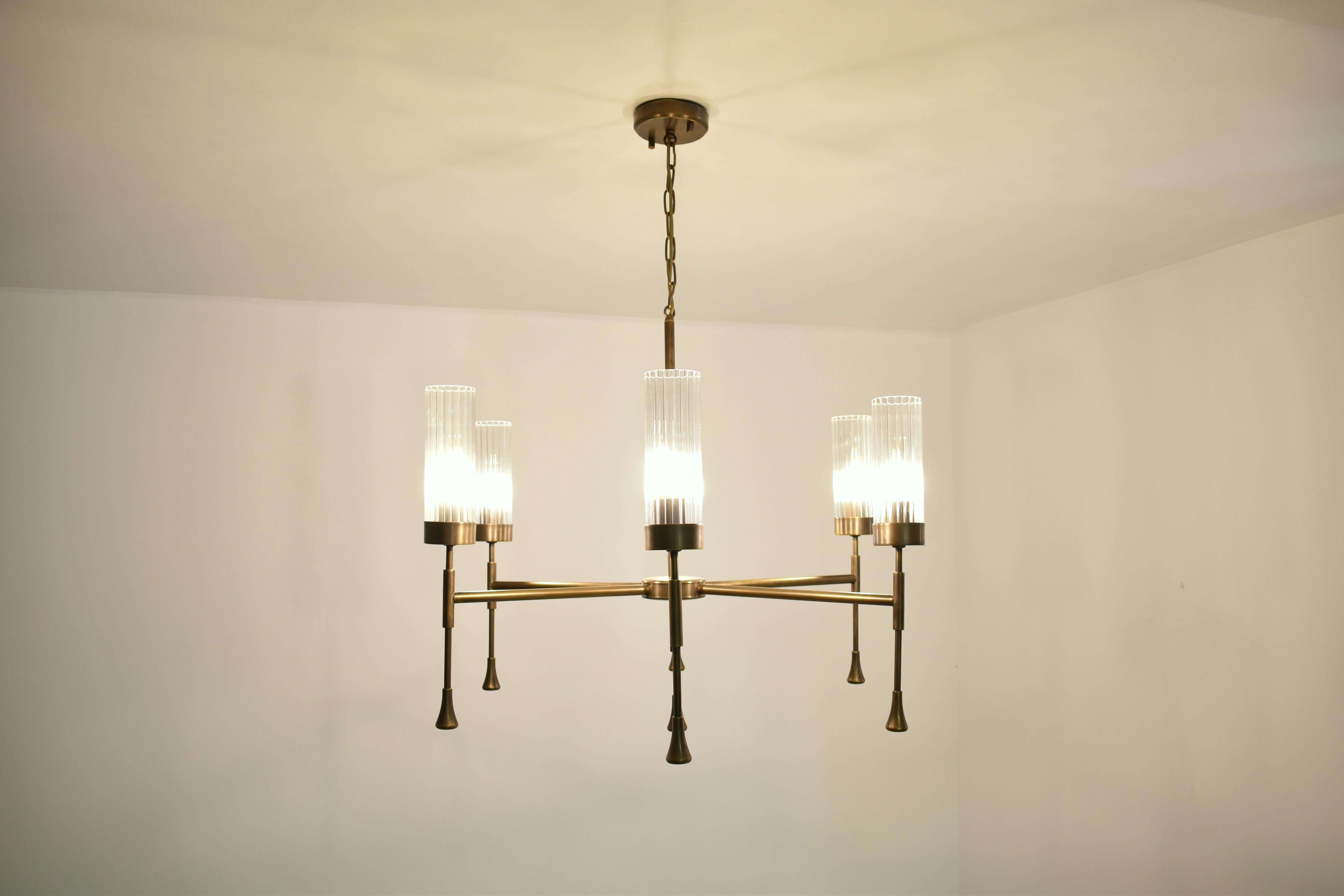 Handcrafted 6 arms chandelier in a linear solid brass structure designed with rigged handblown glass shades by Jonathan Amar Studio. 
 ----
Height adjustable 
Available brass finishes: polished or aged.