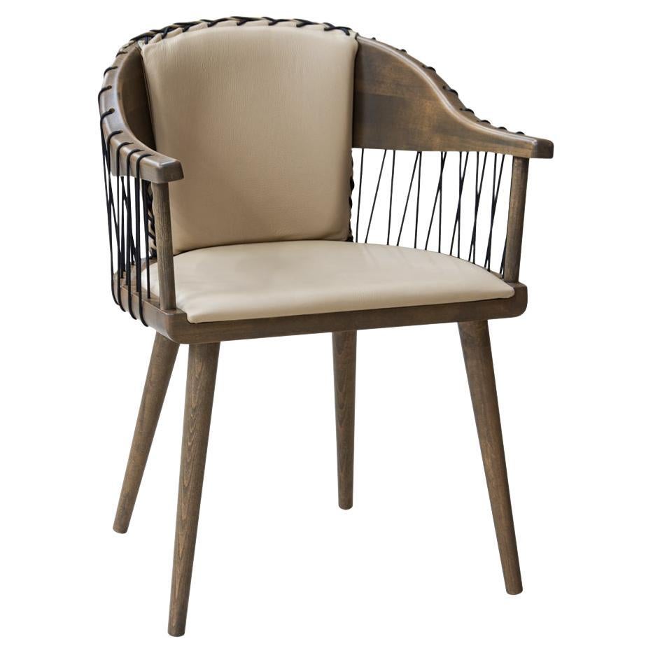 Contemporary armchair crafted of solid wood frame in walnut finish, with upholstered seat and back and a string rope detail for the back and arms.
Seat and back cushions are offered in beige leather.
Available upholstered in various fabrics,