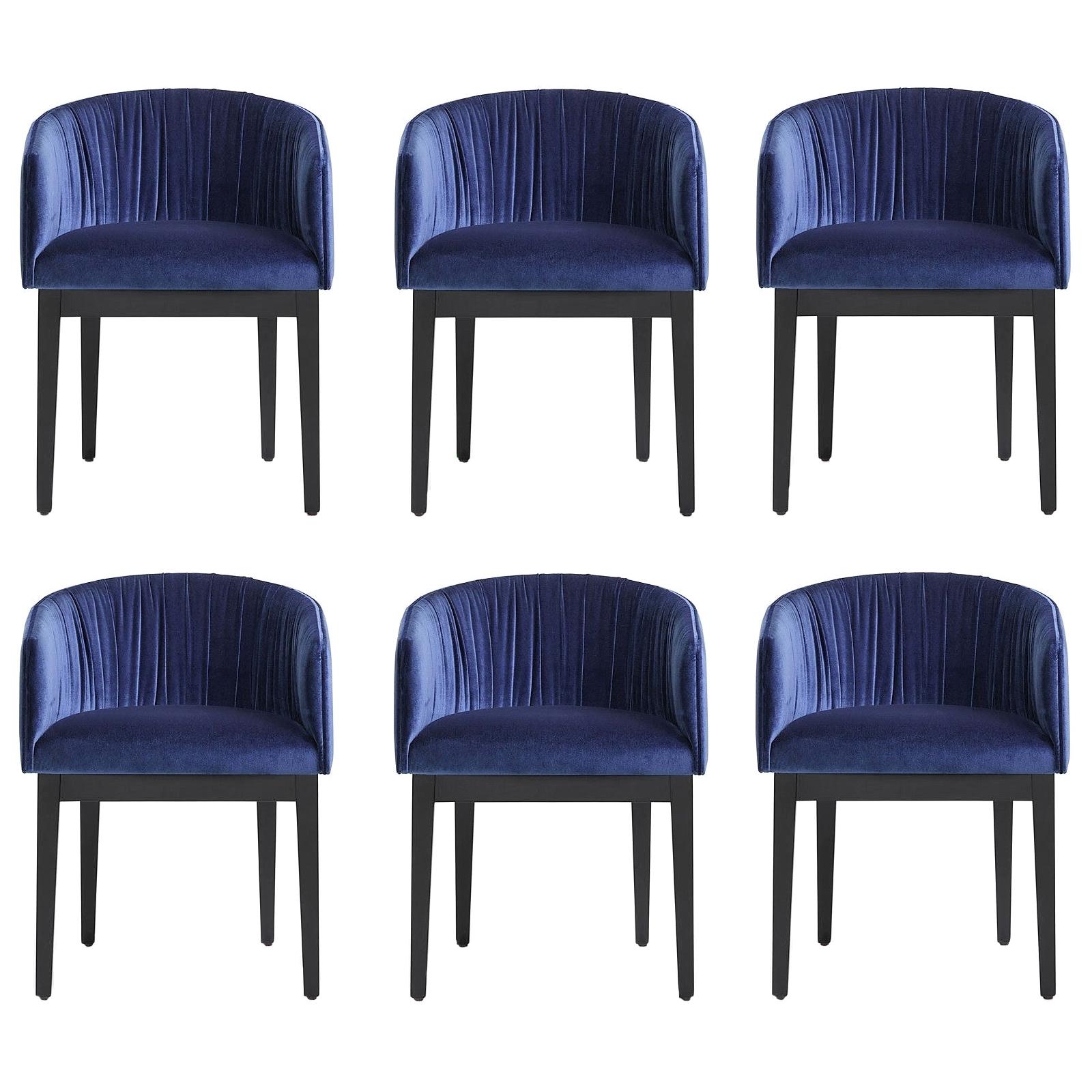 Der marineblaue Samtbezug, die schwarz lackierten Holzbeine und die geschwungene Silhouette sind ein zeitlos elegantes Design, das sich problemlos in jeden Einrichtungsstil einfügt. 
Dieser Stuhl ist robust konstruiert und für den Einsatz im