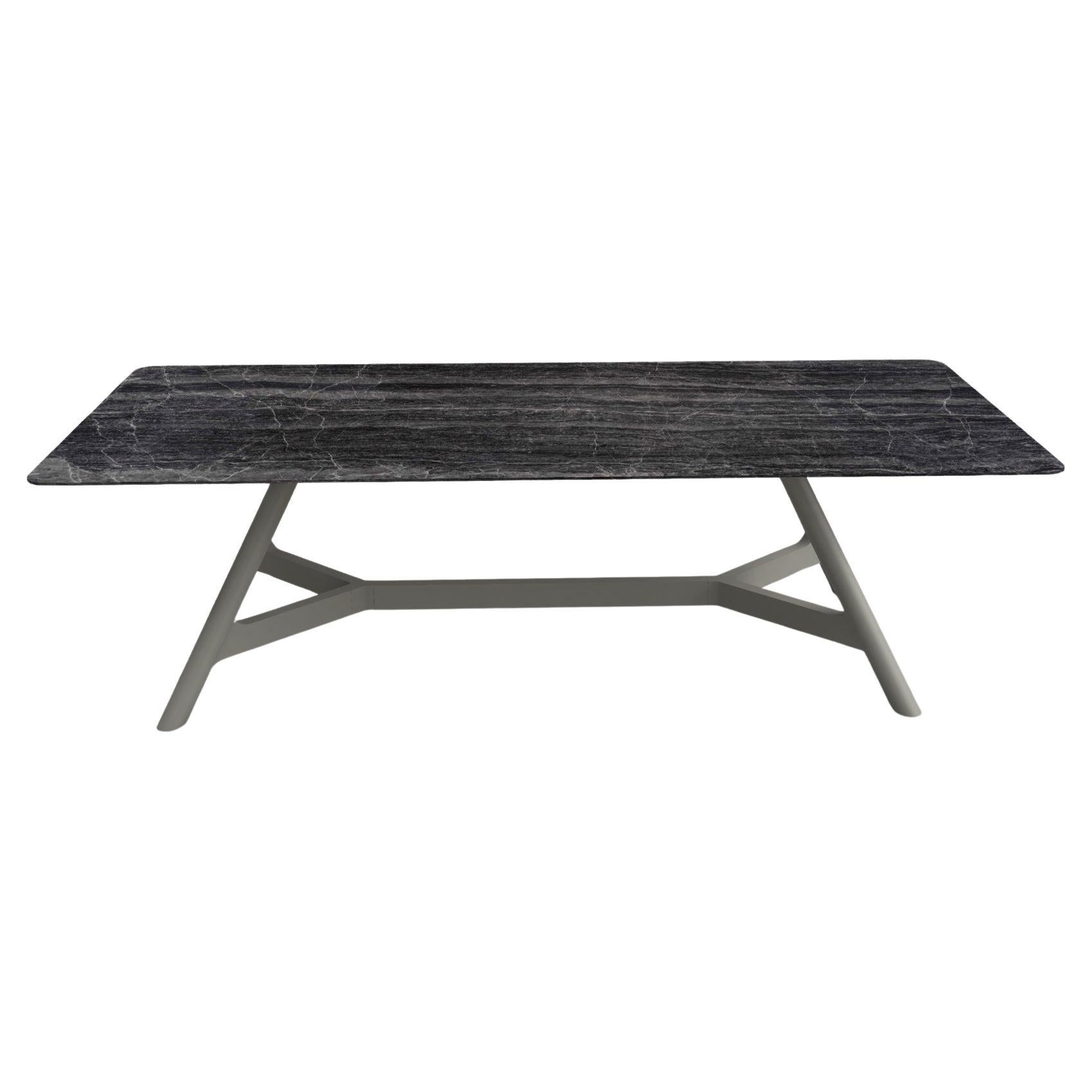 Questo tavolo da pranzo è un capolavoro di design senza tempo. Presenta un piano in marmo rettangolare con angoli curvi, per un look elegante e sofisticato. La base è realizzata interamente in legno massiccio e presenta un design unico che mette in