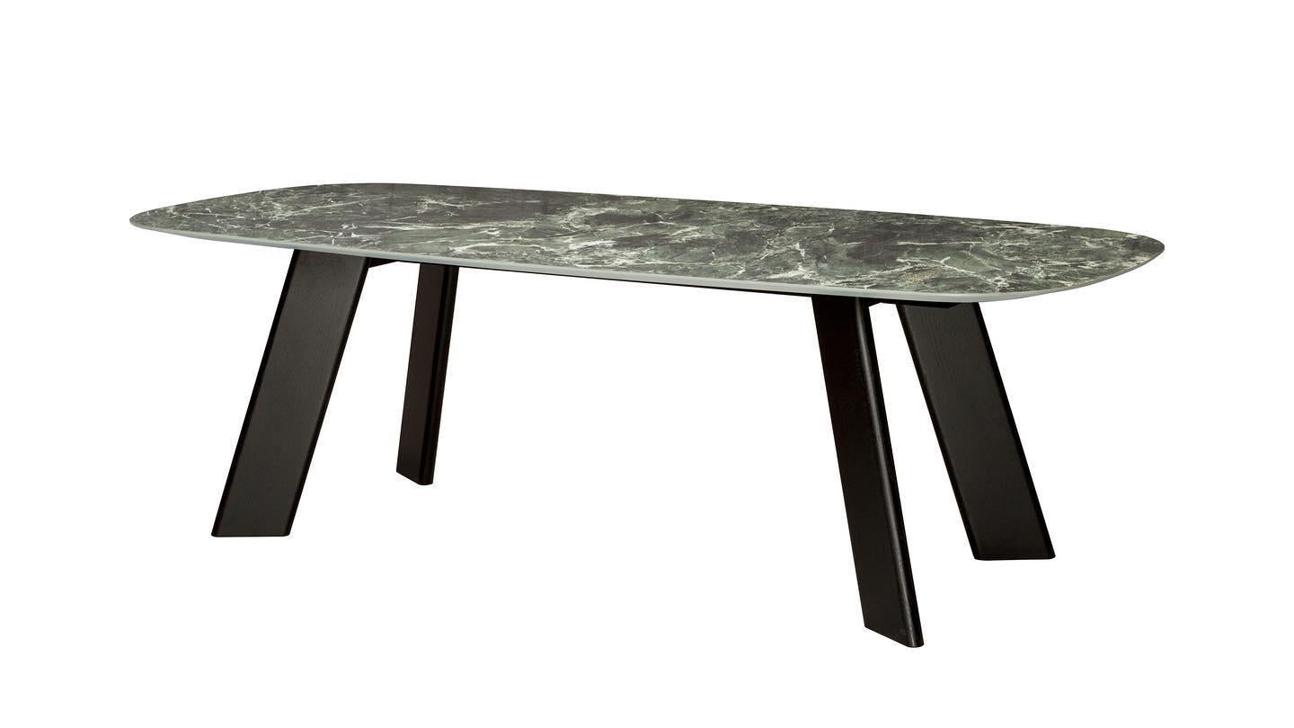 Dining table consists of four solid wood legs lacquered in black. Dark green marble top with a soap shape and shaped edges.
Available in different sizes and different materials such as Solid Oak, Solid Walnut, and Eucalyptus. 
The price is subject