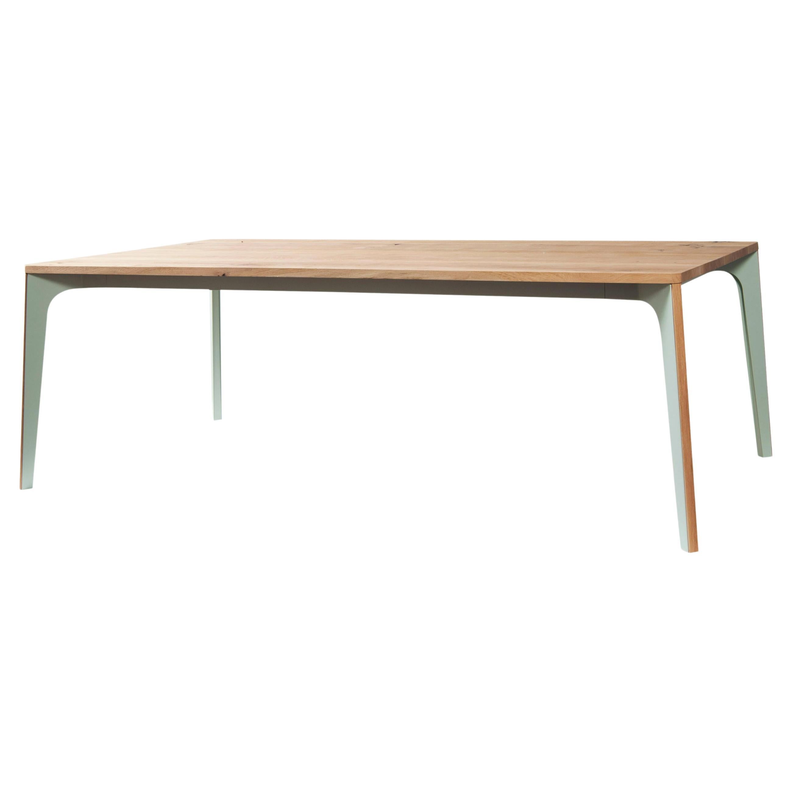 This dining table has a metal structure and a wooden top. There is a wooden profile on the edge of each leg. 
Top : veneer oak.
Available in different sizes and different materials such as Solid Oak, Solid Walnut, Lacquered and Veneer Walnut.
The