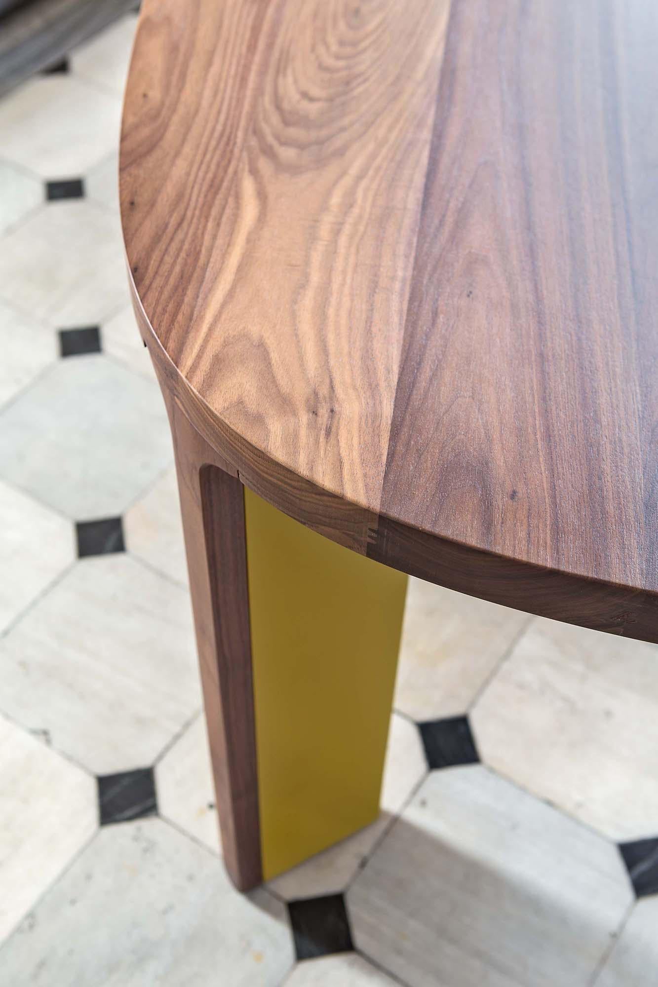 Dining table consists of four legs and a wooden top in an oval shape. Each leg is made in two sections, the internal one which is lacquered in yellow, or any different color from our lacquer selection, and the external one. 
Top: Walnut