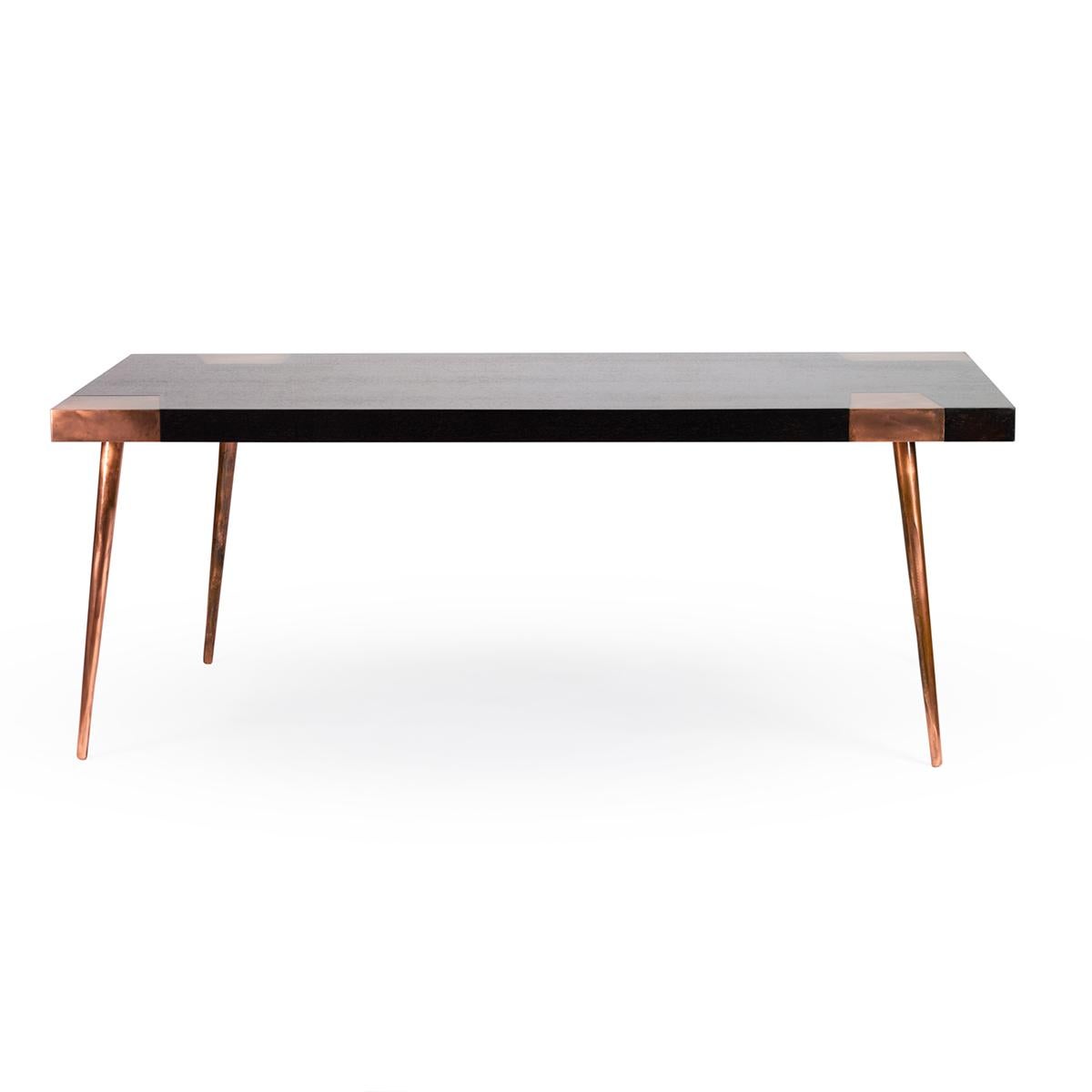 Indigo est une table de salle à manger de style artisanal en placage de noyer ou de chêne et finition en acier cuivré ou en laiton patiné, avec des proportions classiques de salle à manger de cuisine. Les pieds de la table sont proposés en plusieurs