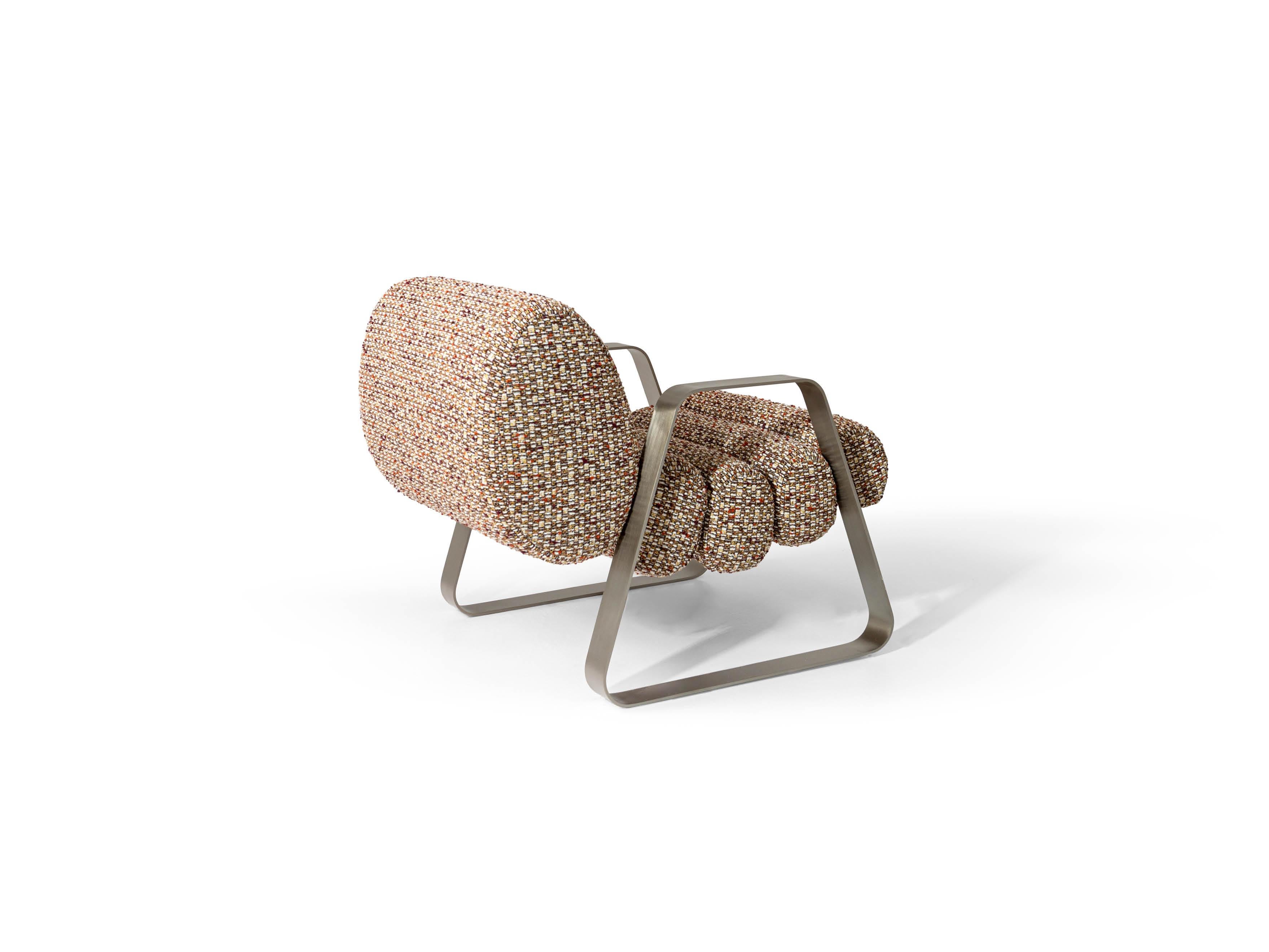 Le fauteuil Dooling se distingue par son design informel. Les parties rembourrées, enveloppantes et soigneusement garnies, sont soutenues par deux éléments métalliques trapézoïdaux de grande taille qui servent également d'accoudoirs. Une large gamme