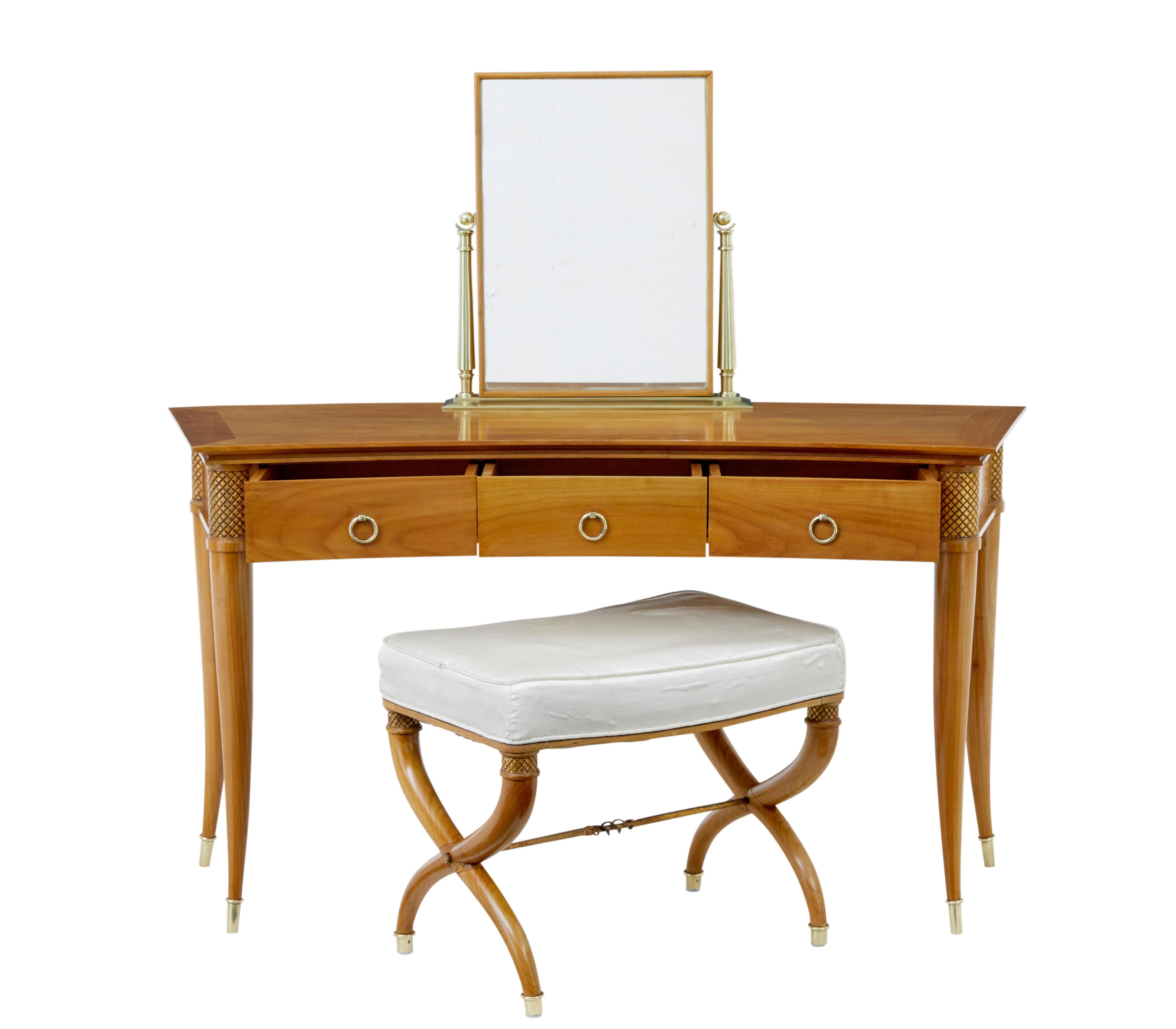 Contemporary dressing table and stool in cherry circa 1990.

Well made in cherry wood, concave shaped dressing table with decorative brass fittings for the adjustable mirror.  3 drawers above the knee fitted with brass ring handles.  Decorative