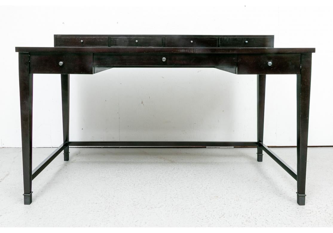A very well made writing table with a great Minimal feel. With sleek lines and a raised top with four short drawers. The apron with three drawers and center knee hole. Raised on square tapering legs with spade feet and 3/4 square stretcher. 

L.