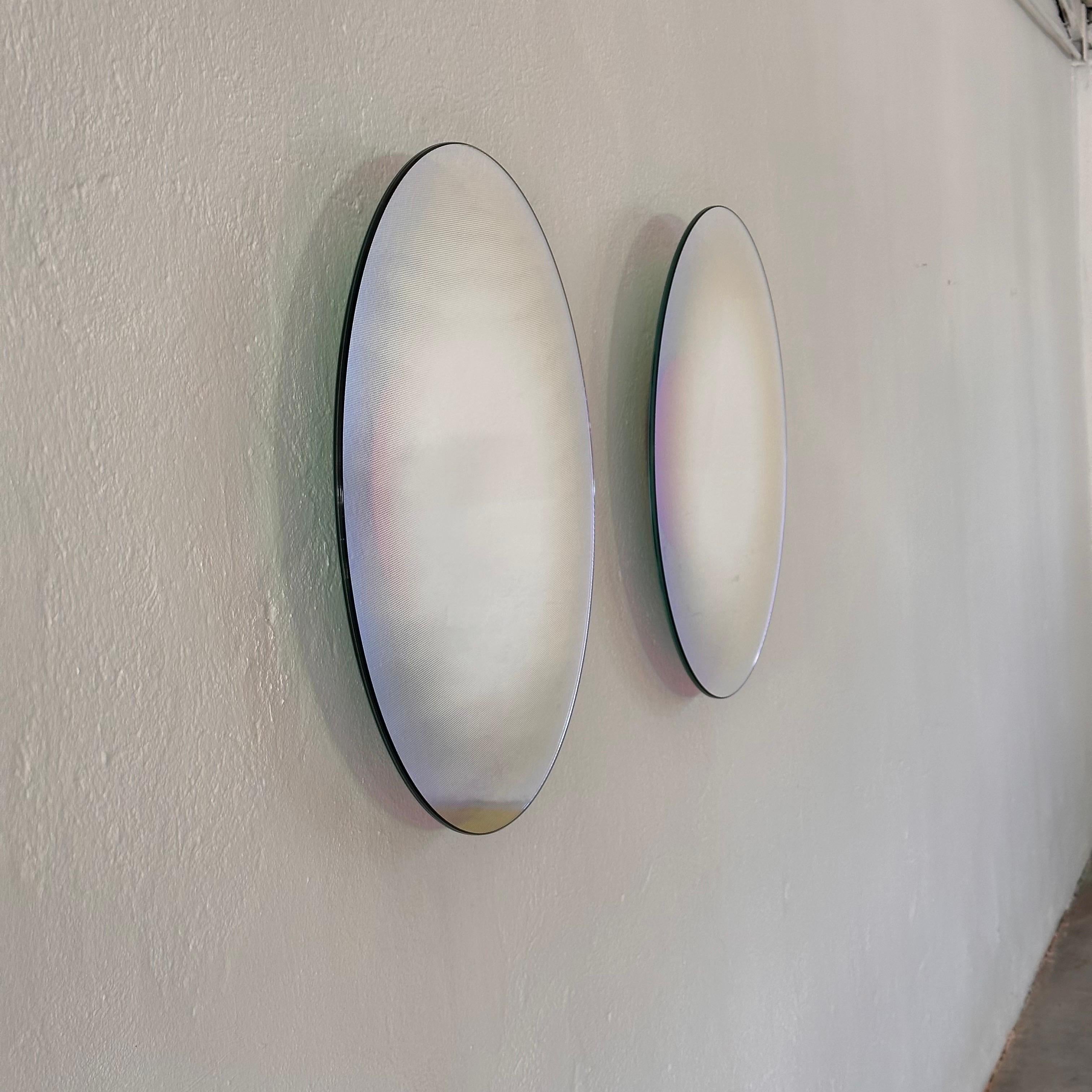 Indulge in the captivating allure of modern design with this exquisite pair of Shimmer mirrors by renowned designer Patricia Urquiola. Crafted in 2015, these mirrors epitomize sophistication and innovation, showcasing Urquiola's signature style