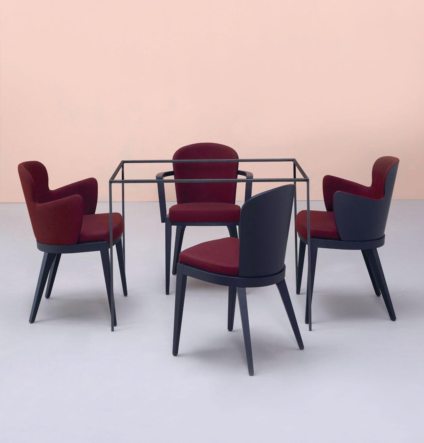 Timeless design in combination with handmade couture techniques. The Italian dining chairs features curved wooden upholstered back for greater support and comfort. offered in wengè finsihed frame and woven wine fabric that is resistant to stains and