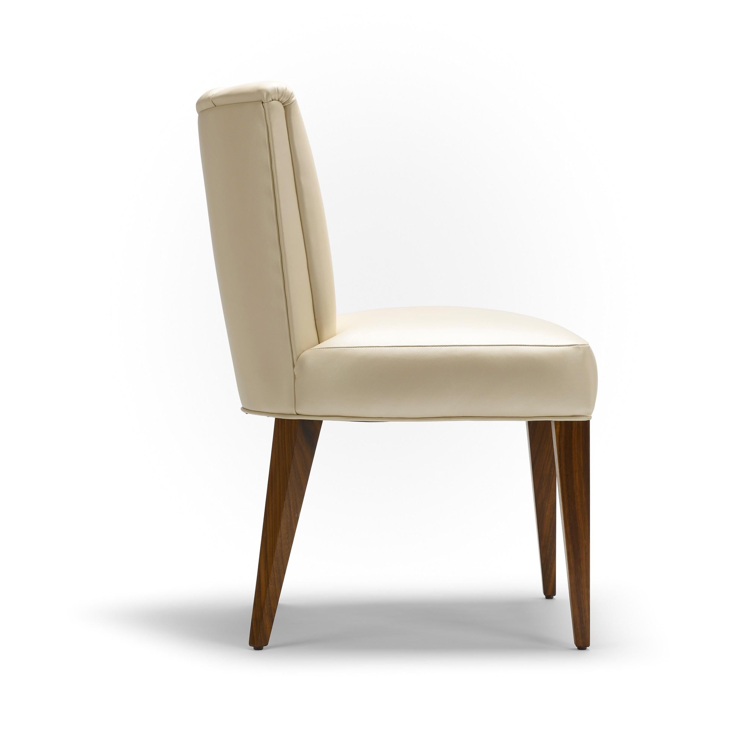 A sophisticated and simple silhouette with beautifully detailed flutes. This dining or occasional chair effortlessly appeals. Shown here: upholstered in half grain pearlized leather, with natural oiled walnut legs.

Construction: solid walnut