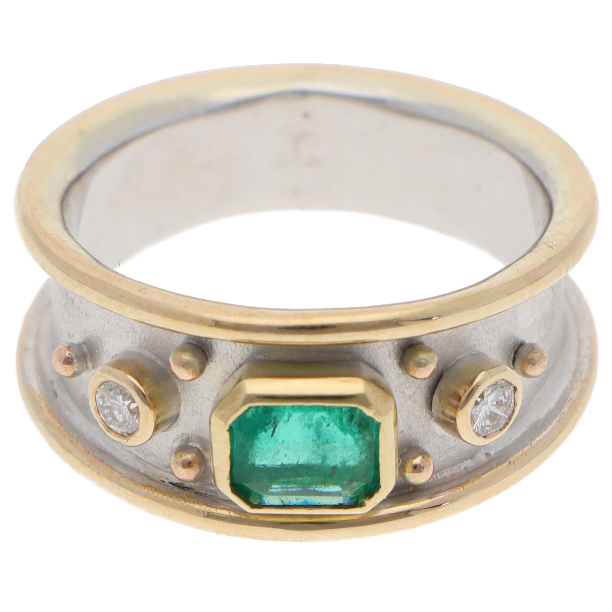 Un bellissimo anello contemporaneo con smeraldo e diamante di ispirazione etrusca, incastonato in oro bianco e giallo 9 carati.

L'anello è incastonato al centro con un vibrante smeraldo tagliato a smeraldo, incastonato a castone in un'incastonatura