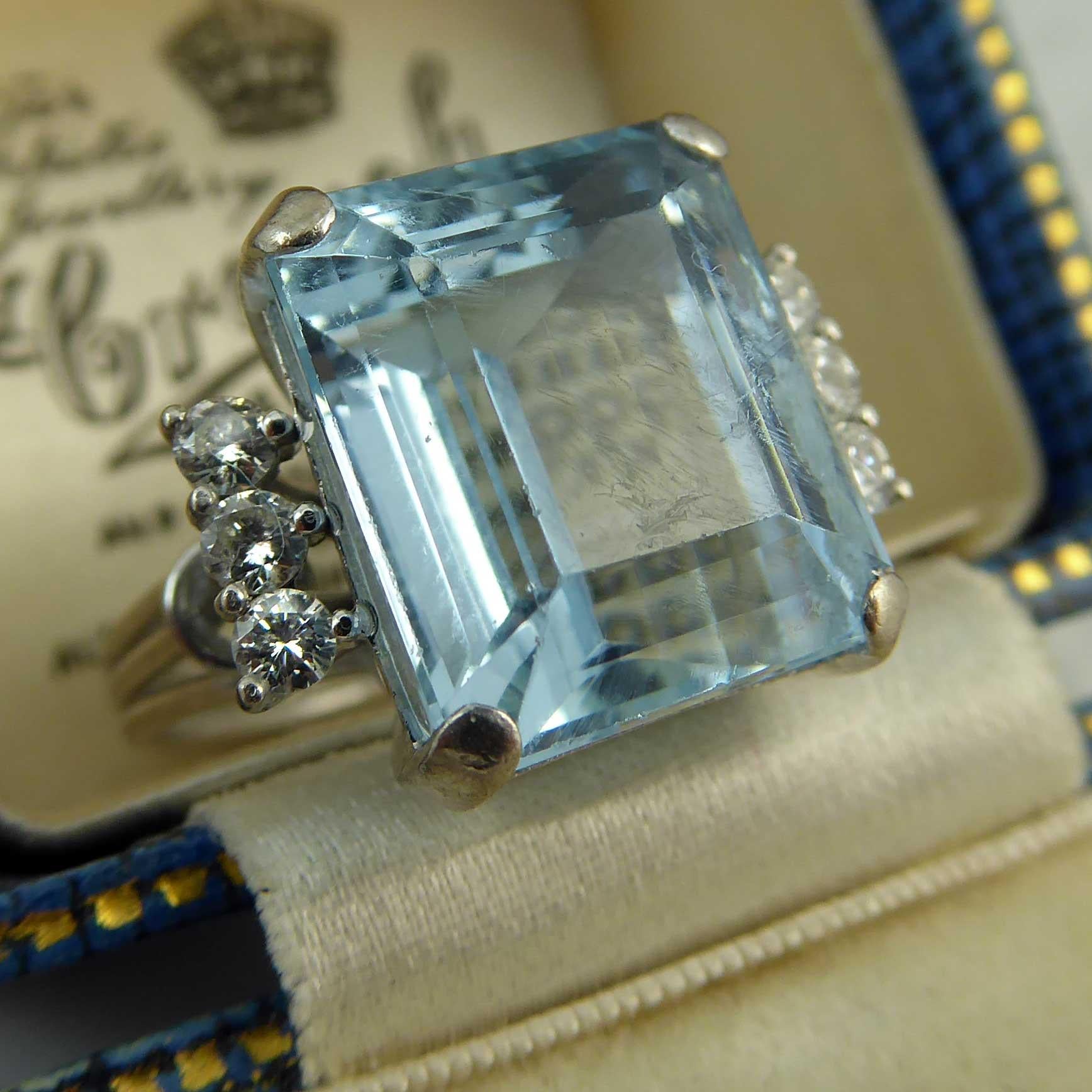 A contemporary aquamarine and diamond ring of quite imposing proportions.  Set with an emerald cut aquamarine which measures some 13.05mm x 11.18mm x 8.60mm deep and with an estimated carat weight of 8.43ct.  The aquamarine is set in a handmade,
