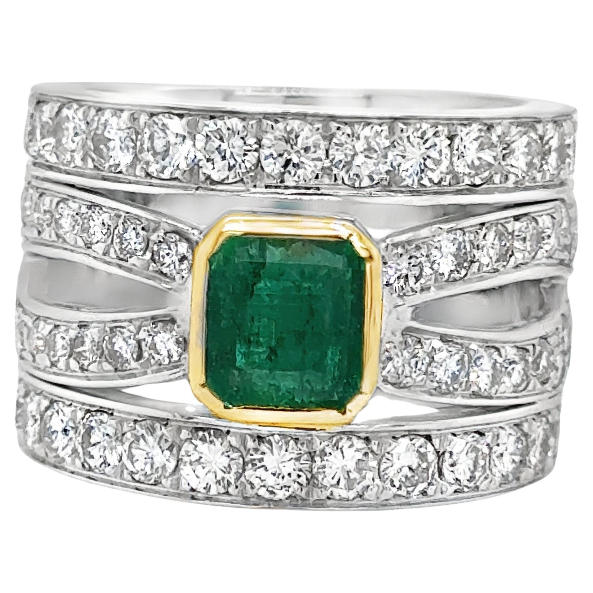 Beautiful ring crafted in 18k gold. The ring highlights one emerald gemstone in the center that displays a vibrant green color. The emerald gemstone is encased in a yellow gold basket and engulfed by earth mined natural diamonds. 
 This two toned