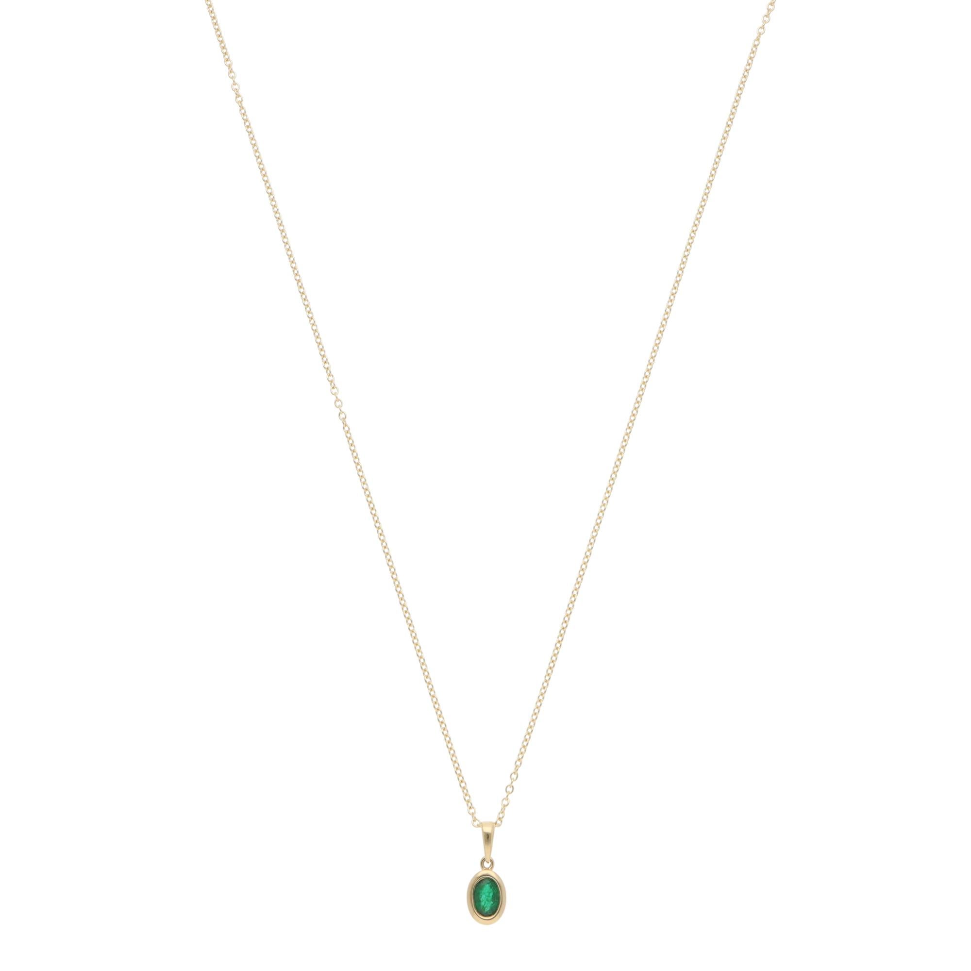 A beautiful contemporary emerald pendant necklace set in 18k yellow gold.

The necklace solely features a vibrant oval mixed-cut emerald, which is securely set in an open gallery bezel setting. The true beauty of this piece lies in the minimalistic