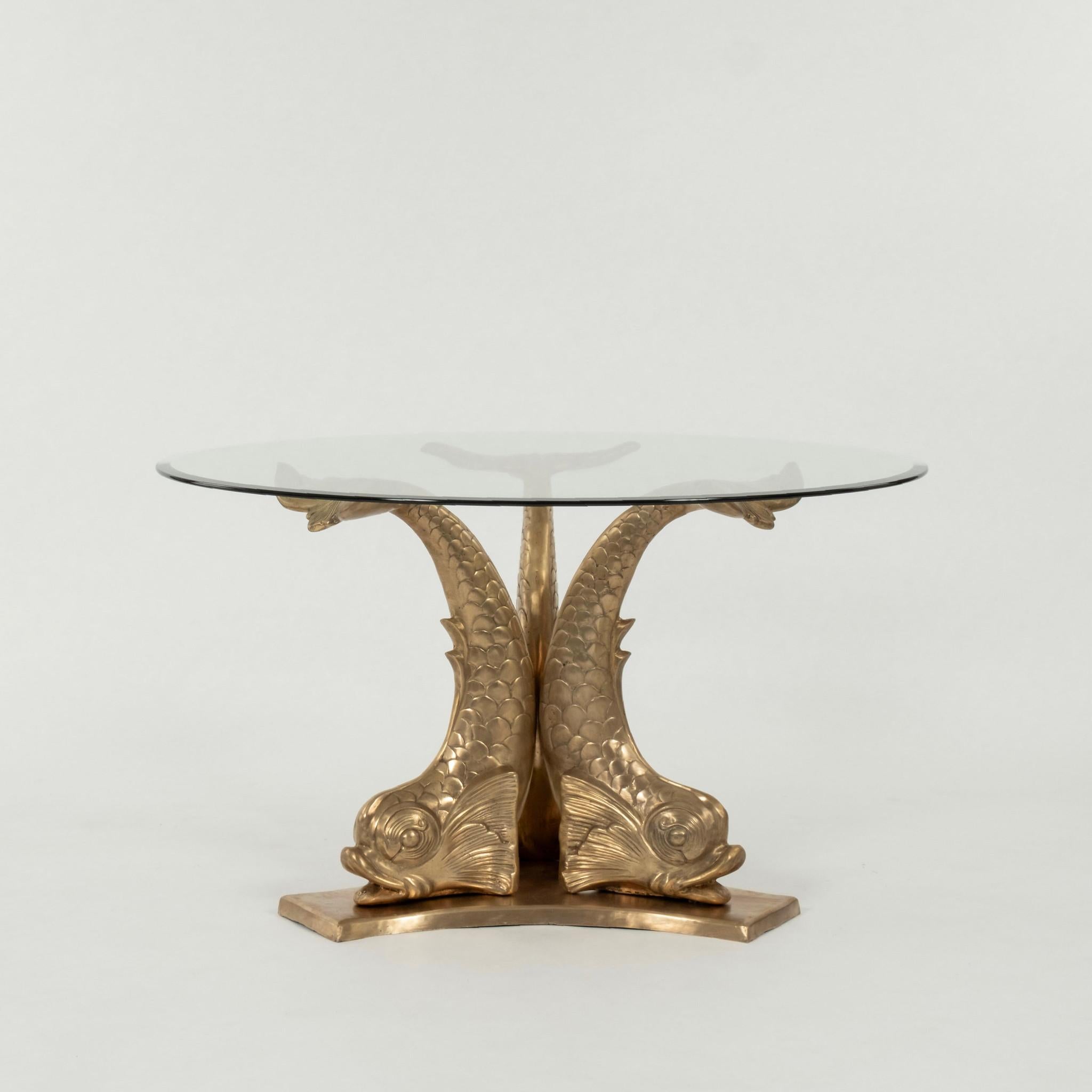 A chic vintage brass dolphin pedestal dining table with 48