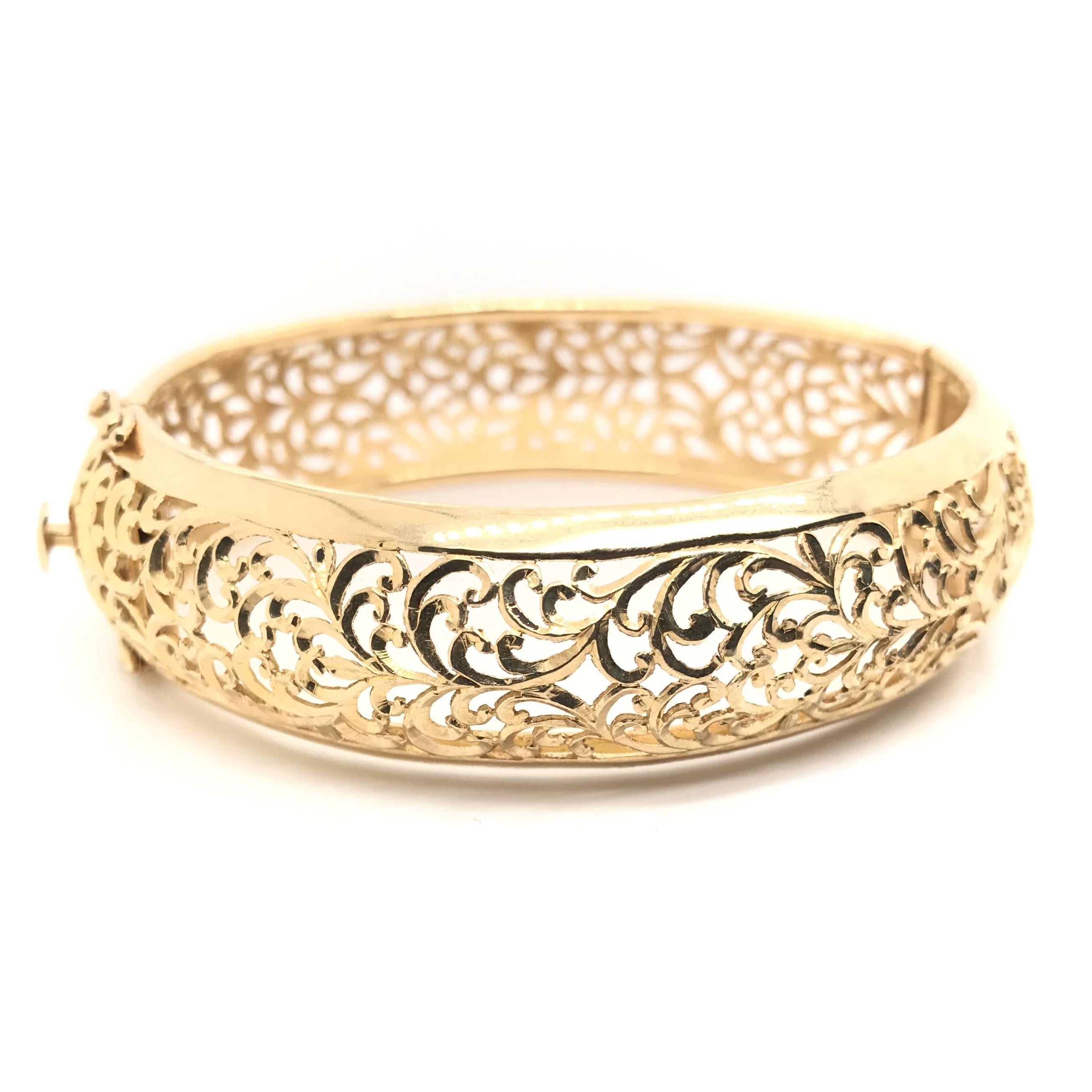 This enchanting contemporary estate piece features jaw dropping antique inspired filigree encompassing the entire length of the bangle. The filigree is arranged in a rich flourishing motif, so intricate and beguiling it is an instant signature