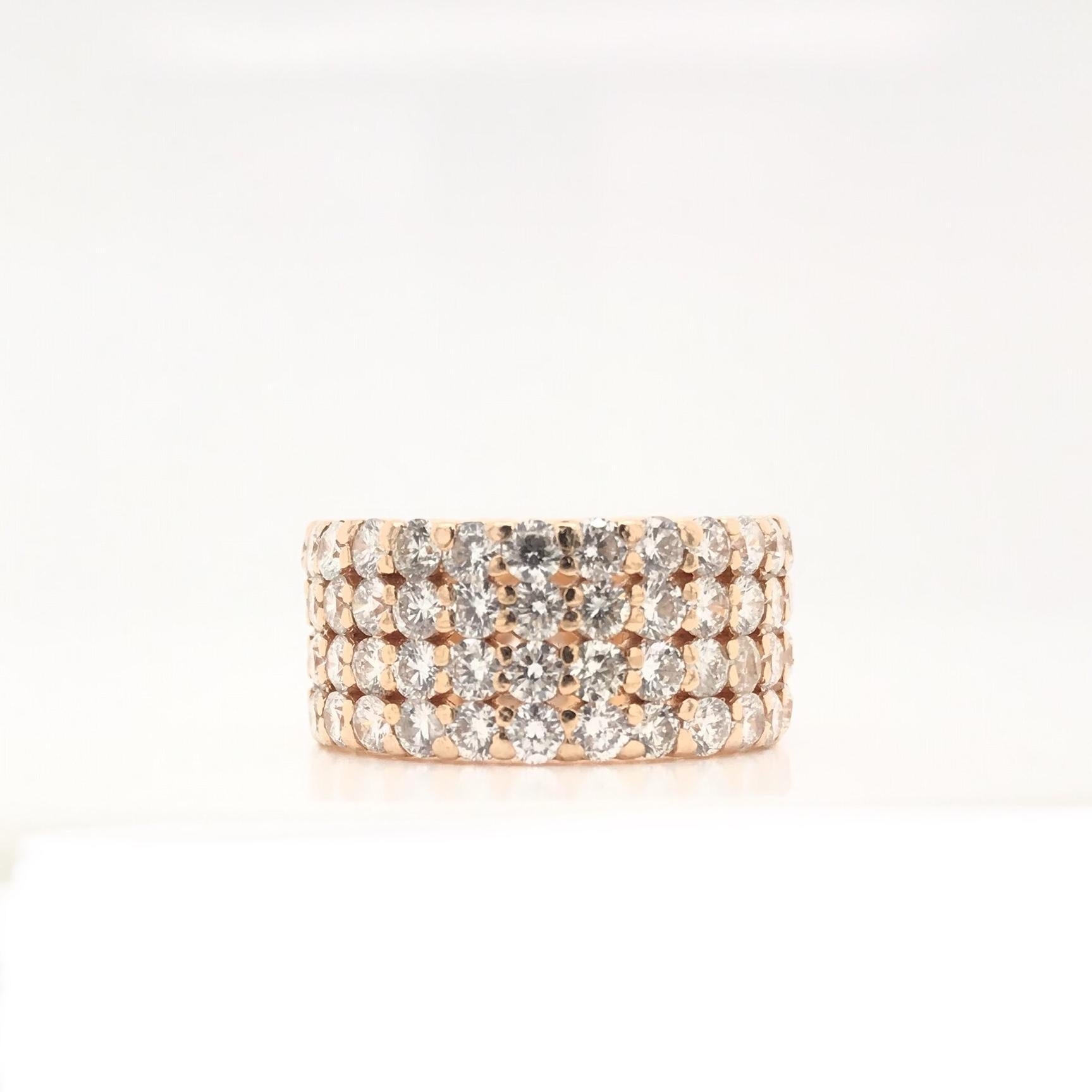 This exceptional contemporary piece features five carats of dazzling white diamonds set in 18K rose gold. The 104 diamonds grade approximately H in color and SI1 in clarity. This wide designer style band would function beautifully as an alternative