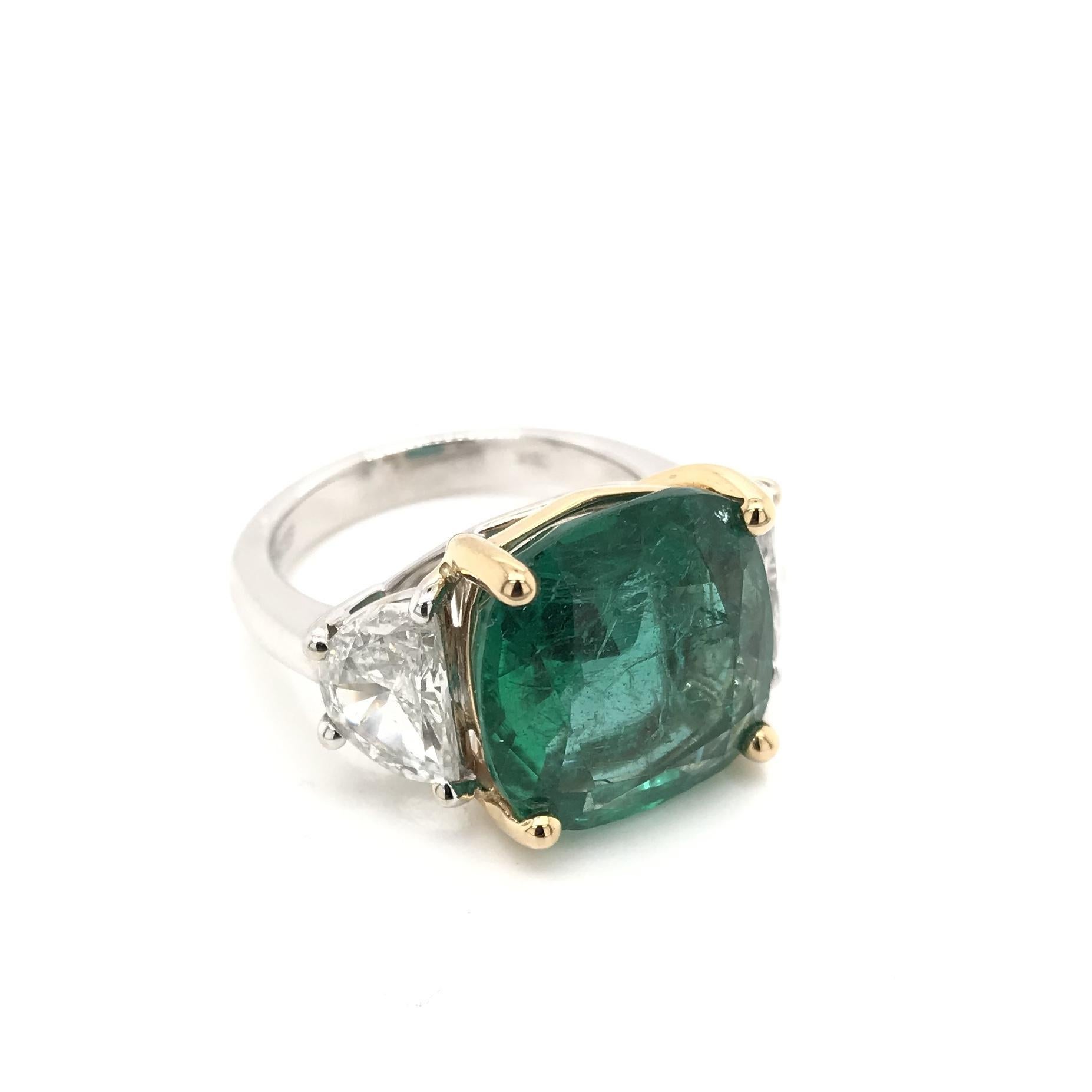 This exquisite contemporary estate piece features an emerald measuring approximately 7.88 carats. The emerald has been certified by the Gemological Institute of America (GIA). The center emerald is cushion cut and certified natural. The classic 18K
