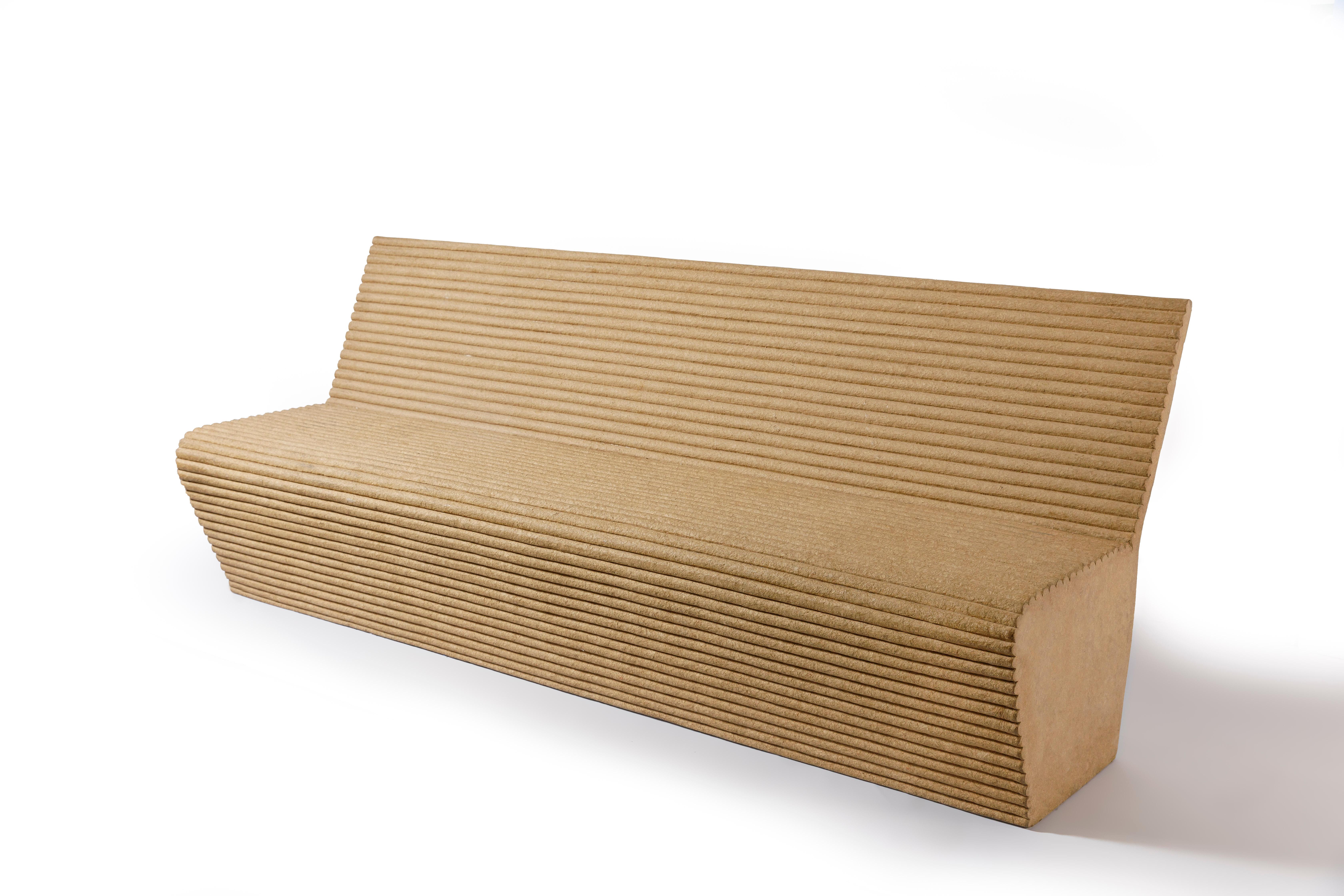 The Contemporary Estriado Bench by Domingos Tótora is a unique and stunning piece of furniture created in Brazil in 2014. The bench is made entirely of recycled cardboard, meticulously crafted into a series of vertical ribbons that are layered and