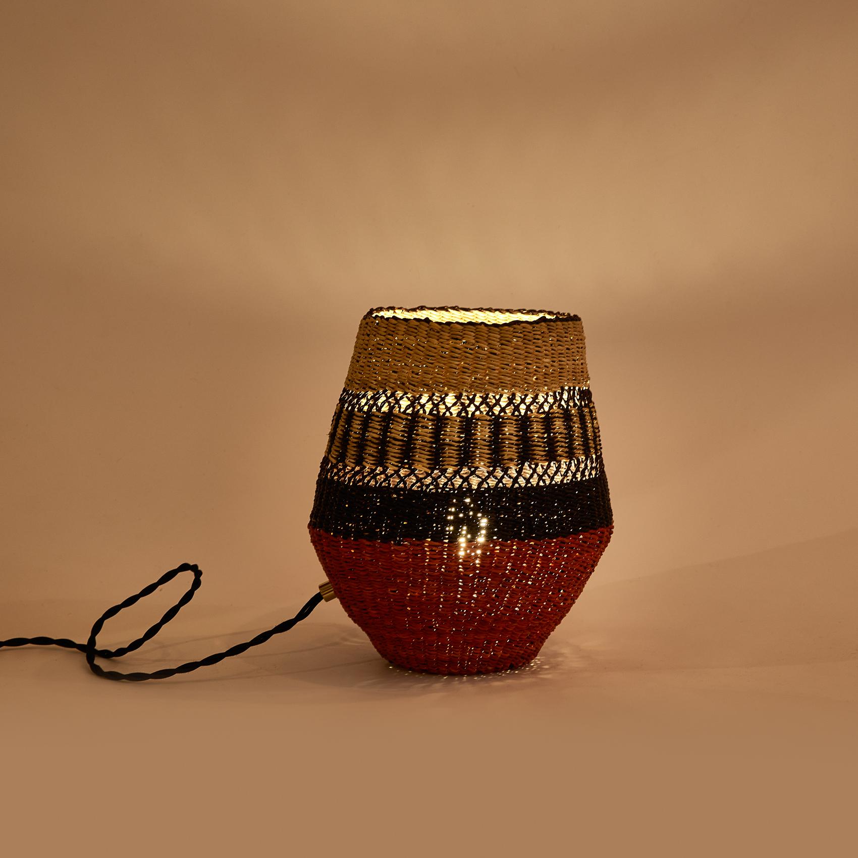 Woven table lamp
Colours: Natural and Black punctuated by a Terracotta Red

Are you looking for unexpected objects to decorate your home? This base shaped table lamp is delicately woven and will be a funky element in your room (measuring