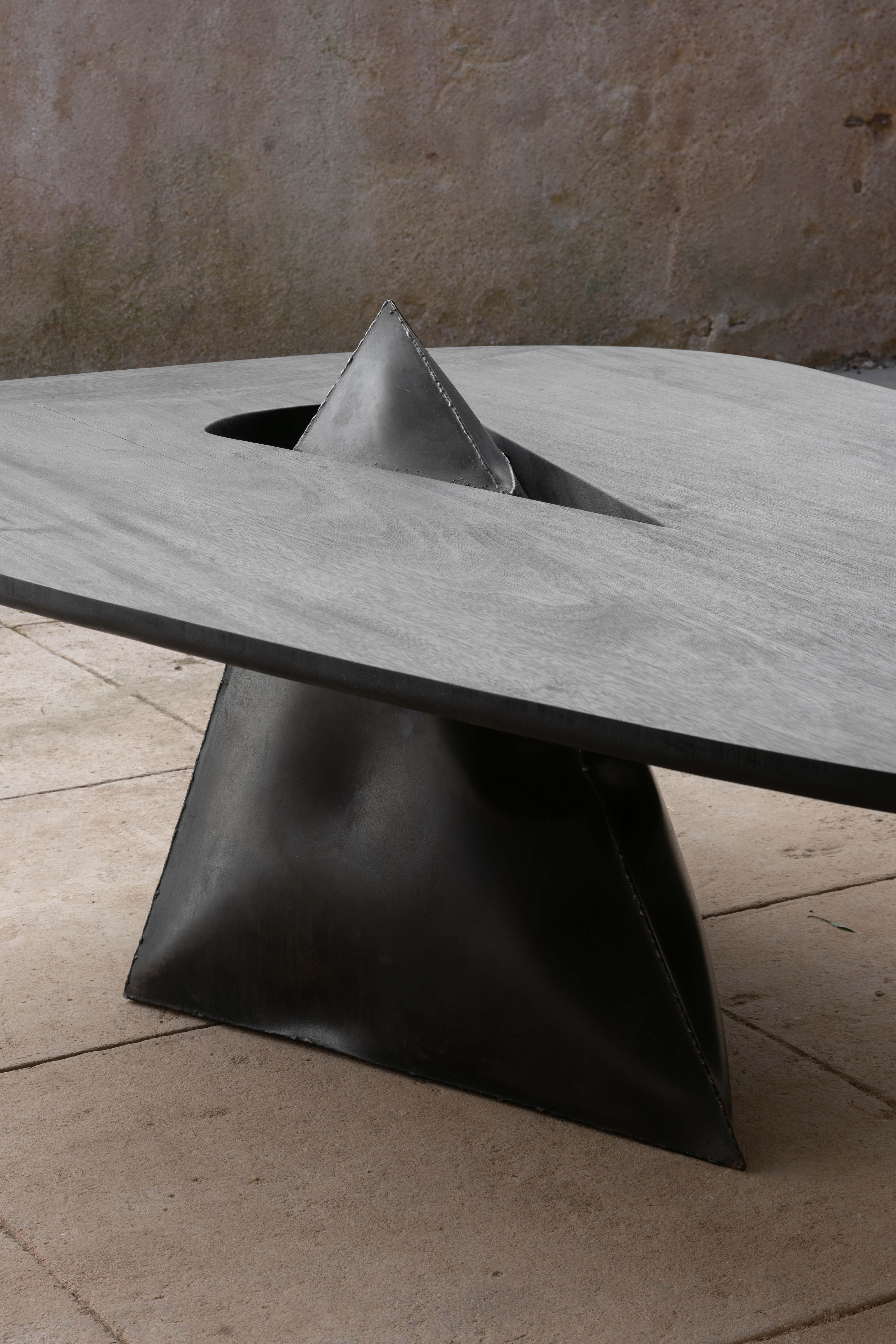 Lose Control Table is handcrafted using only two elements: a Metal Volume spontaneously shaped by an explosion, and a highly treated, hand shaped piece of Burnt Zazange Wood. One element slots into the other in a seemingly precarious manner,