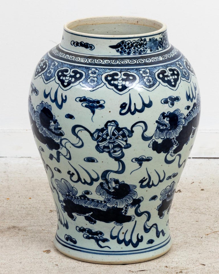 Circa 2000 contemporary extra large blue and white Chinoiserie style ginger jar depicting motifs of painted lions with blue lion finial on the lid. Made in China. Please note of wear consistent with age.