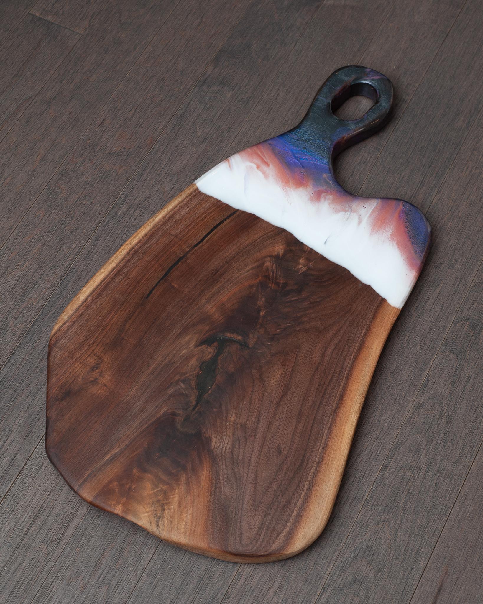 A beautiful large charcuterie board with organic shape and coloured acrylic accent by handle. A perfect serving piece and wonderful holiday gift.