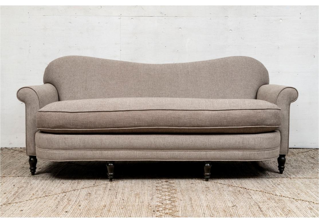 Un puits  canapé contemporain sur mesure avec dossier serpentin, accoudoirs à volutes et assise incurvée avec un seul coussin d'assise. Elle repose sur quatre pieds avant tournés, teintés foncés, et sur des pieds arrière carrés. Tapissé d'un tissu