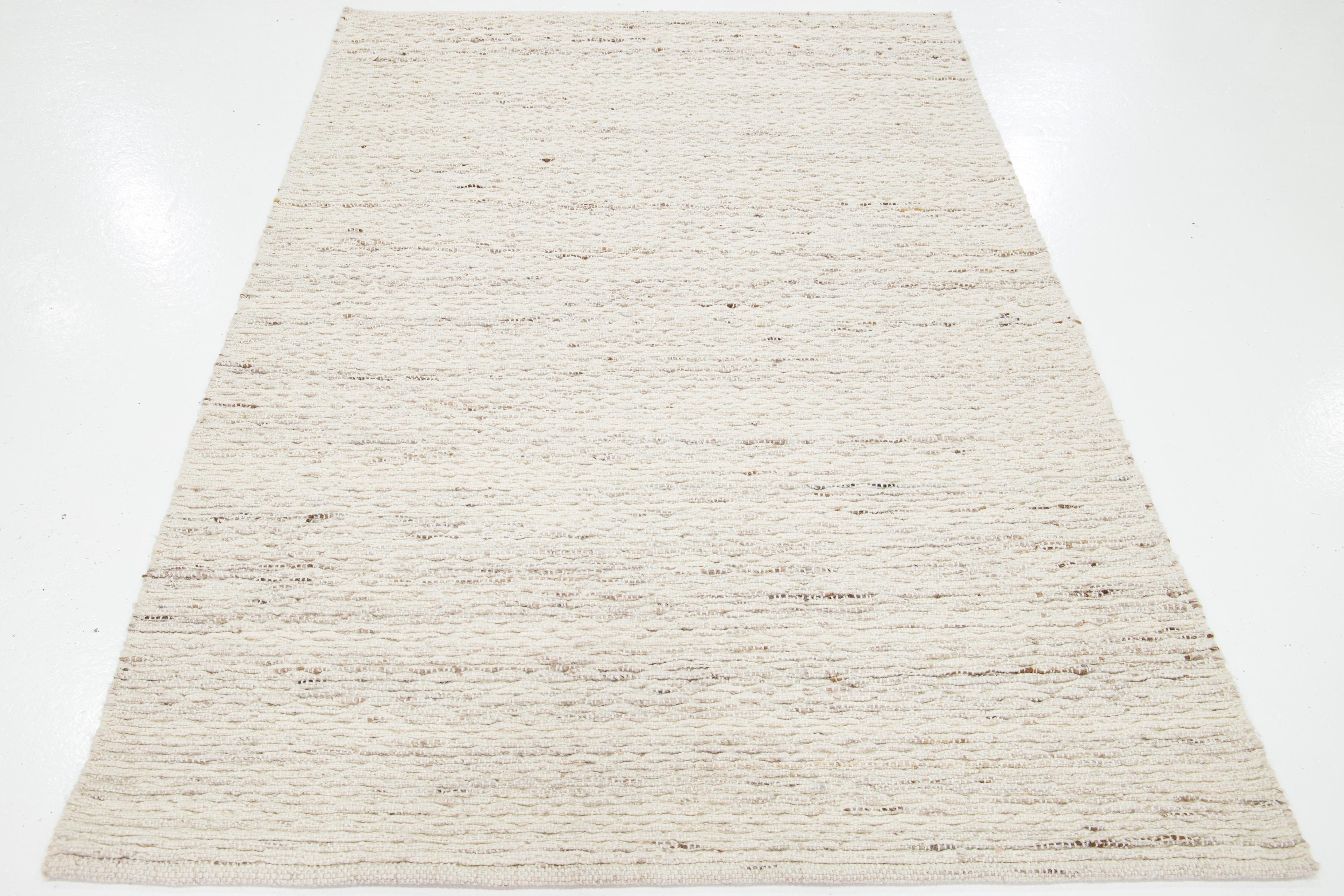 Dieser schöne handgewebte Wollteppich aus Filz ist Teil unserer Westport Collection'S. Es hat ein elfenbeinfarbenes Feld mit einem geometrischen Allover-Muster.

Dieser Teppich misst 5' x 8'.

Kundenspezifische Farben und Größen sind auf Anfrage