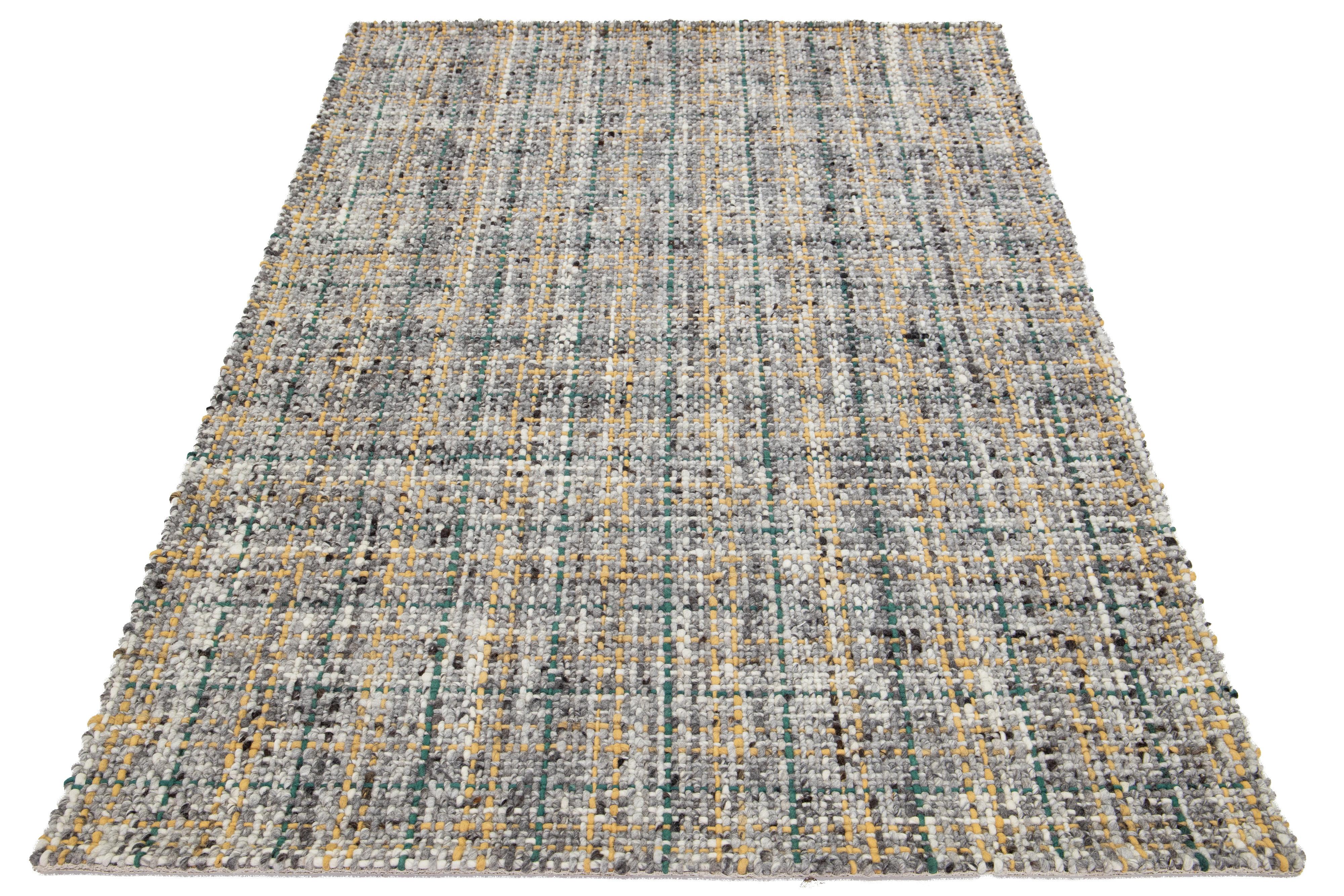 Dieser schöne handgewebte Wollteppich aus Filz ist Teil unserer Westport Collection'S. Es hat ein graues Farbfeld und ein gelbes und grünes geometrisches Allover-Muster.

Dieser Teppich misst 5' x 8'.

Kundenspezifische Farben und Größen sind auf