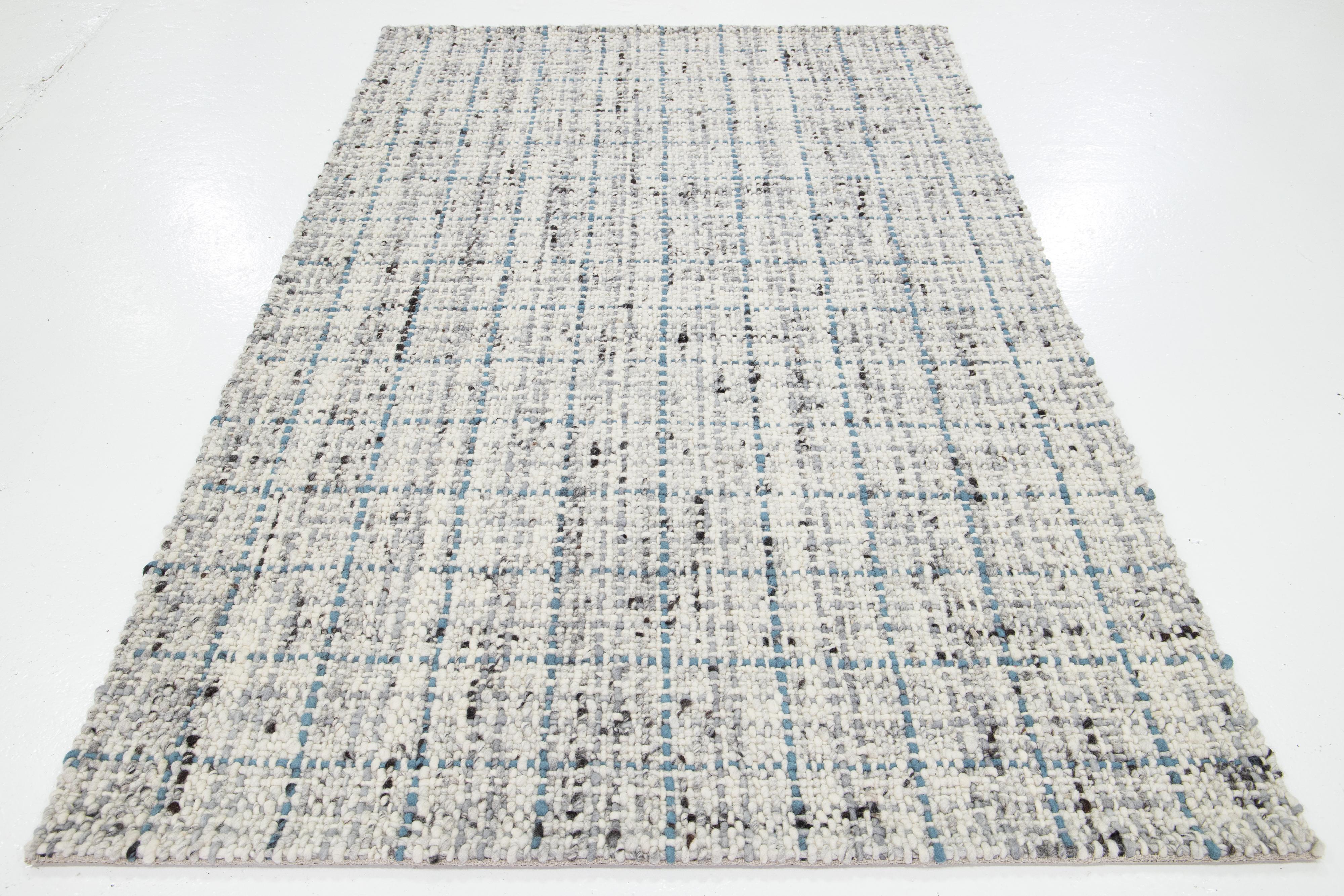 Dieser schöne handgewebte Wollteppich aus Filz ist Teil unserer Westport Collection'S. Es hat ein elfenbeinfarbenes Feld mit einem grauen und blauen geometrischen Muster.

Dieser Teppich misst 5' x 8'.

Kundenspezifische Farben und Größen sind auf